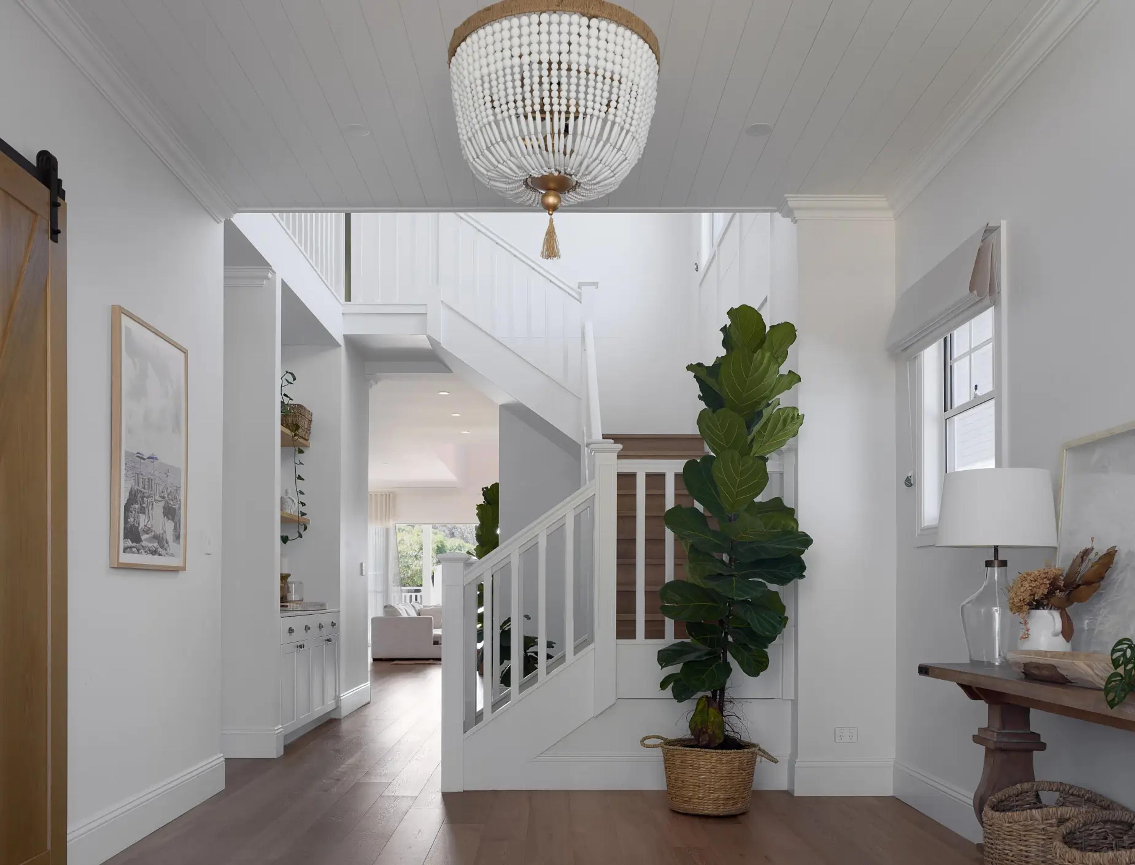 Entry foyer with staircase, beaded pendant light and potted plant