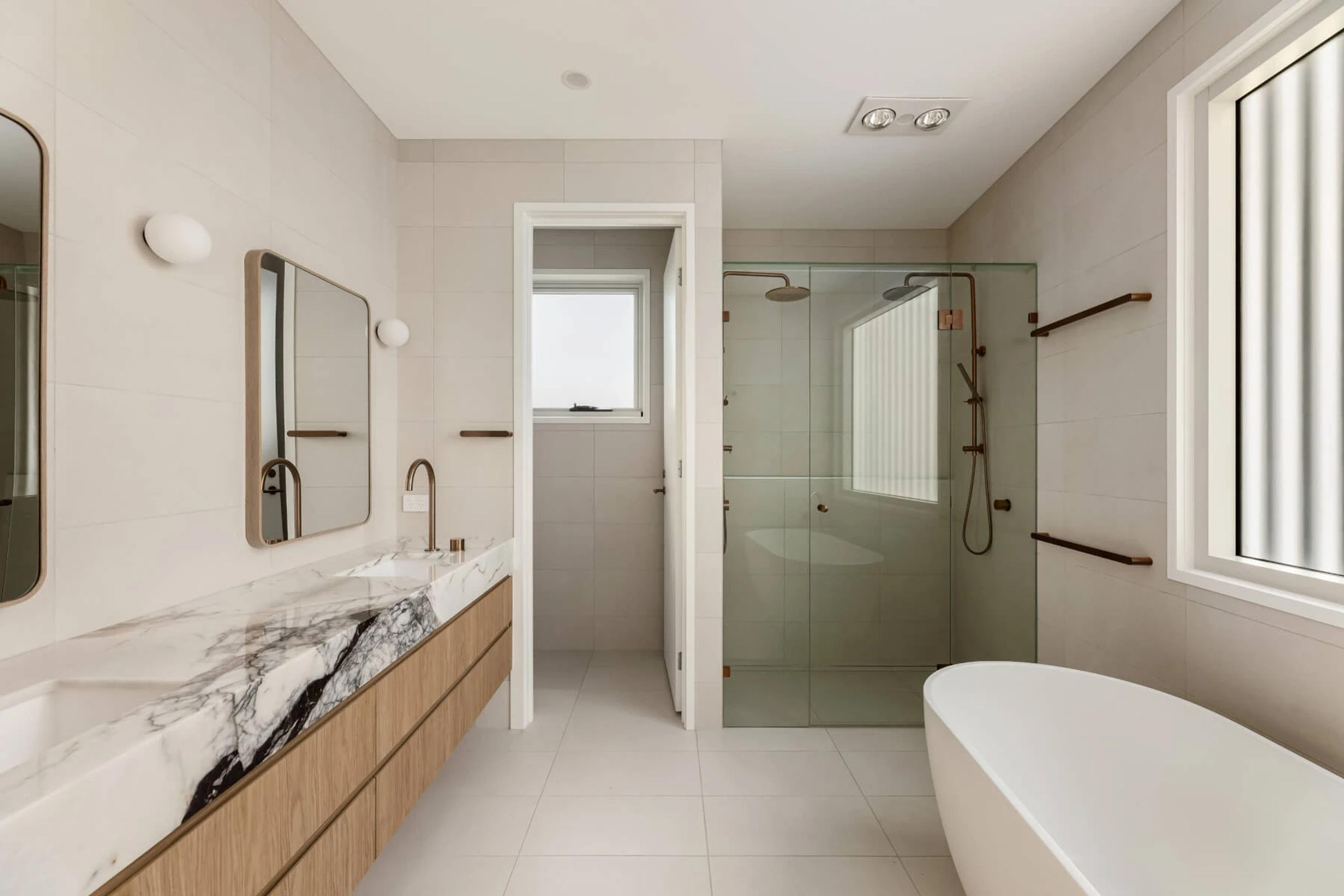 Bathroom with marble vanity, glass shower and freestanding bath