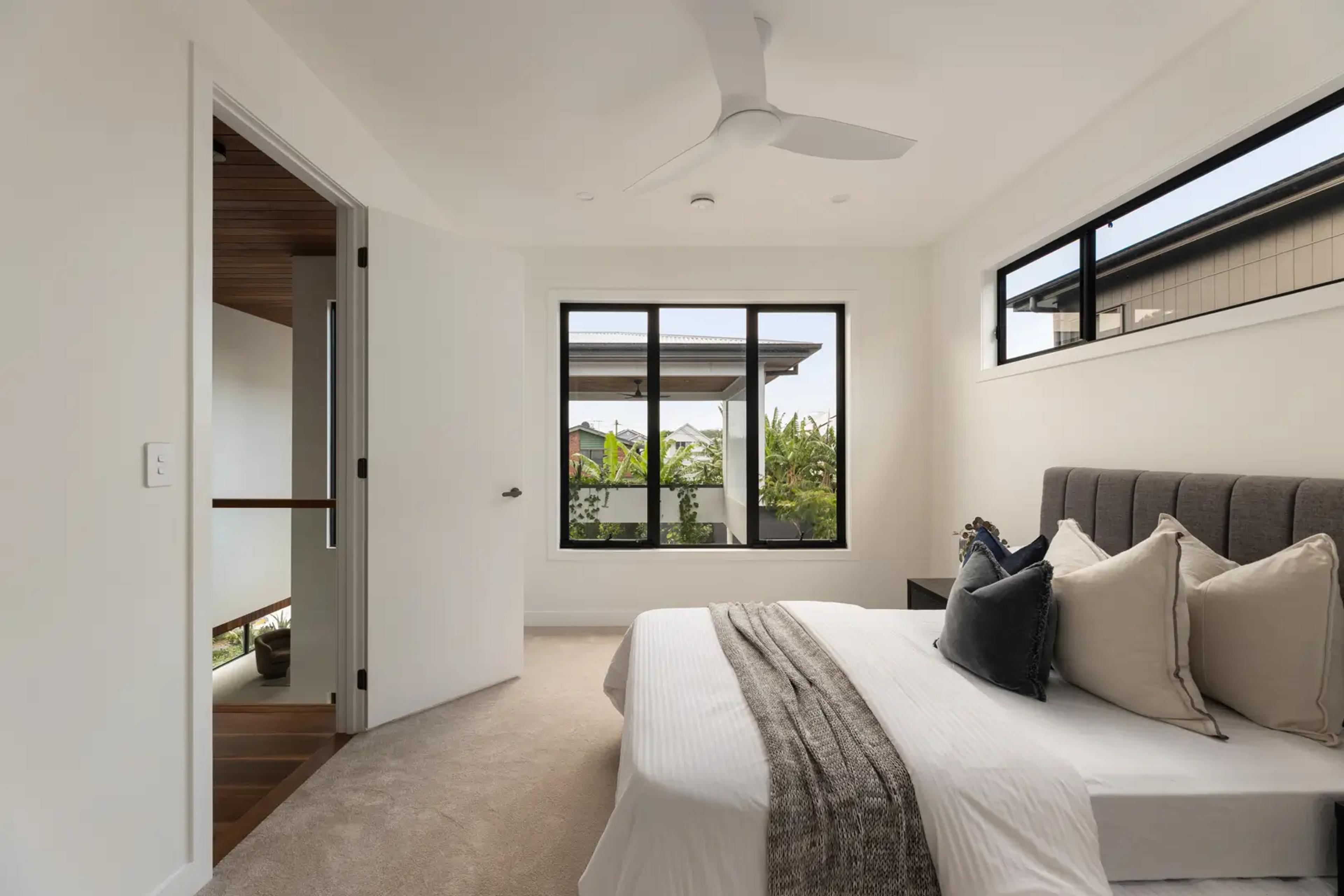 Bedroom with grey headboard and garden outlook