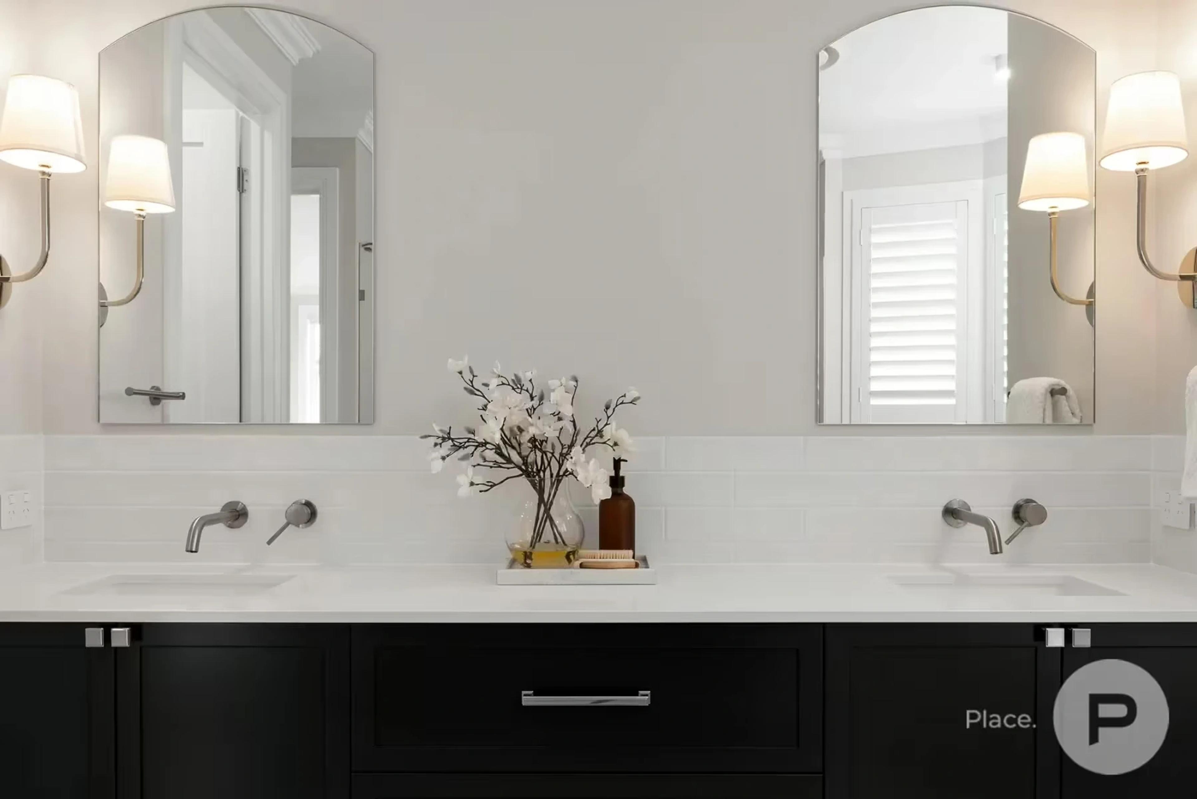 Bathroom vanity with dual basins and arched mirrors