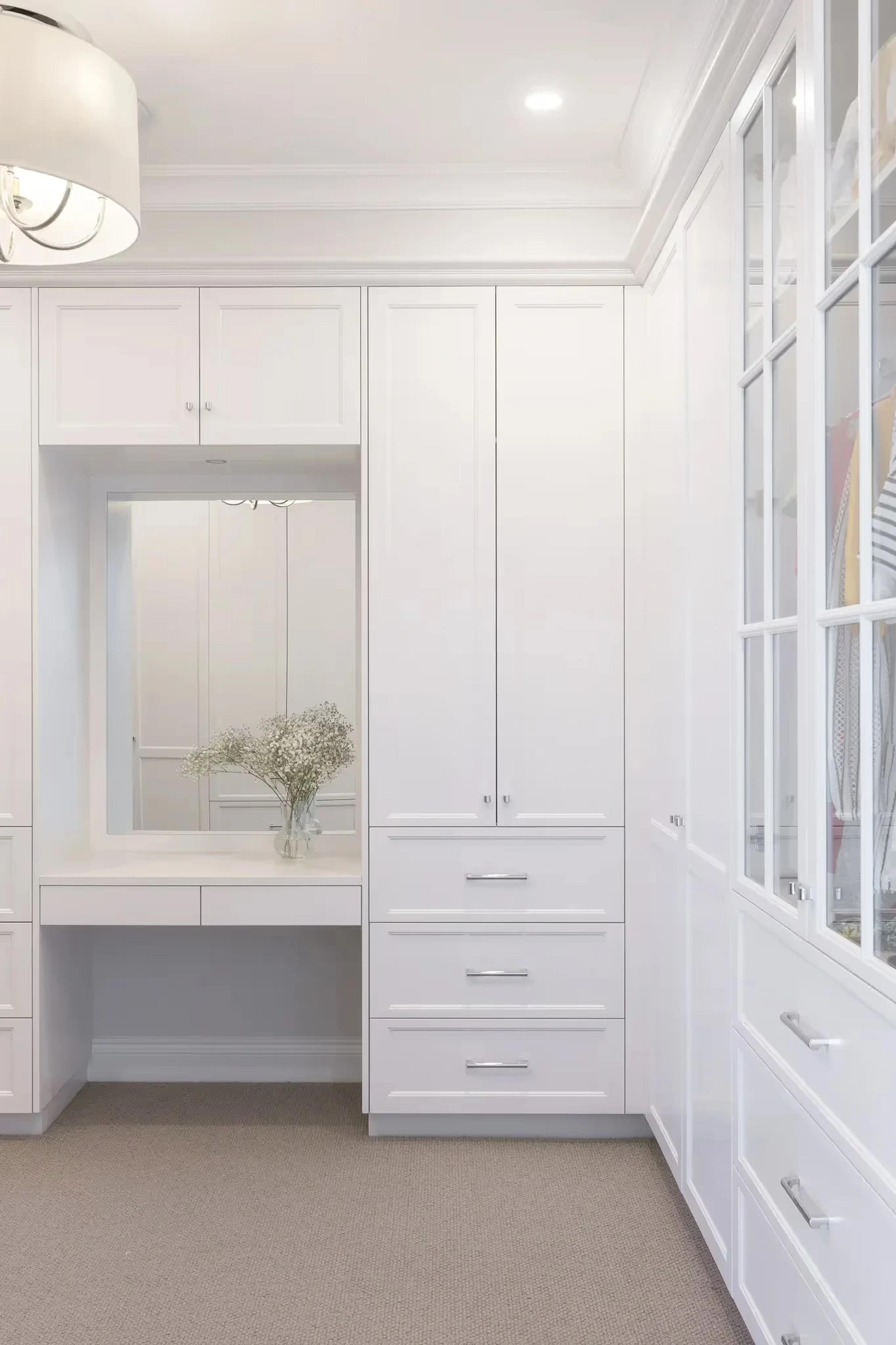 White fitted dressing room with vanity and mirror
