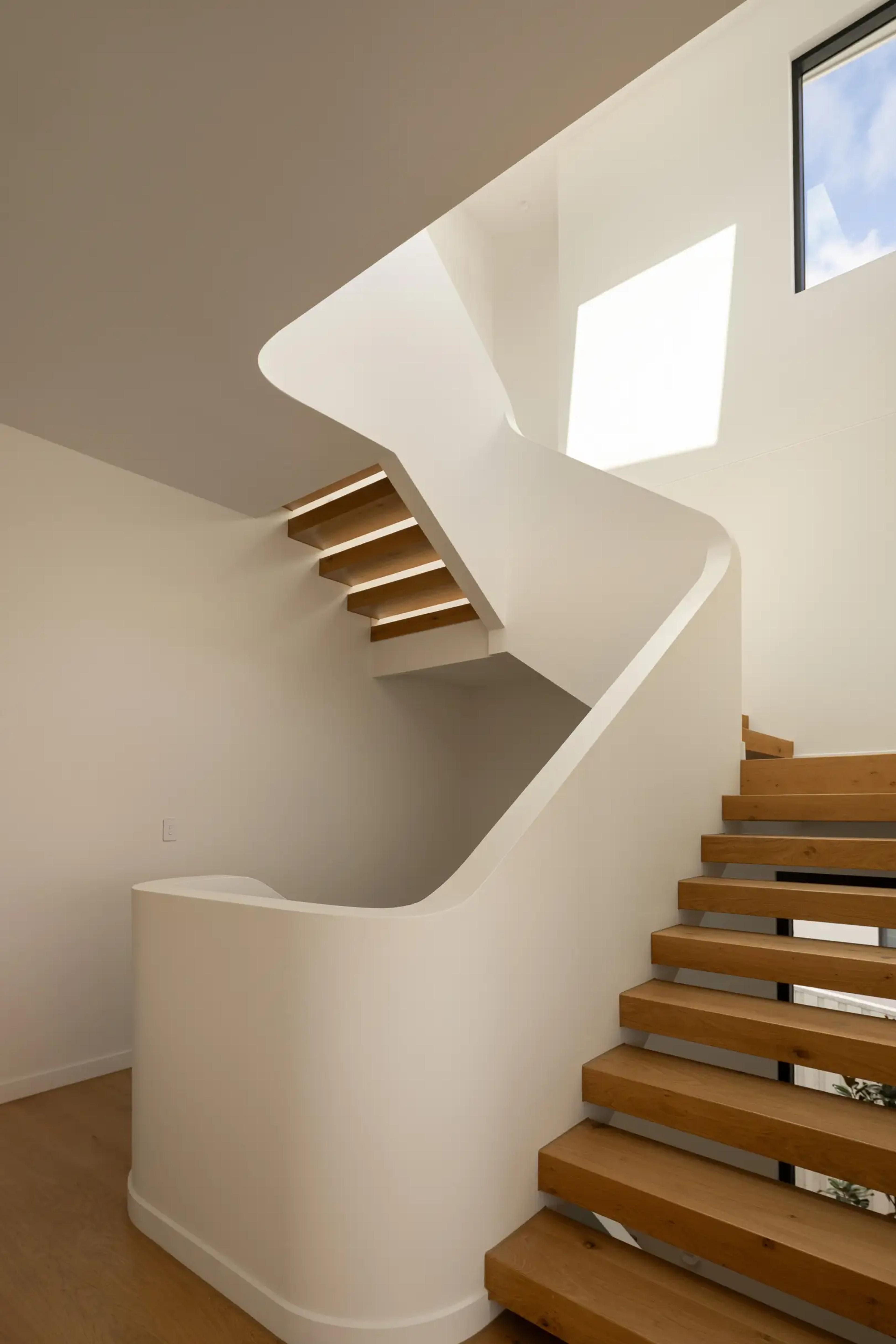 Sculptural white staircase with floating timber treads