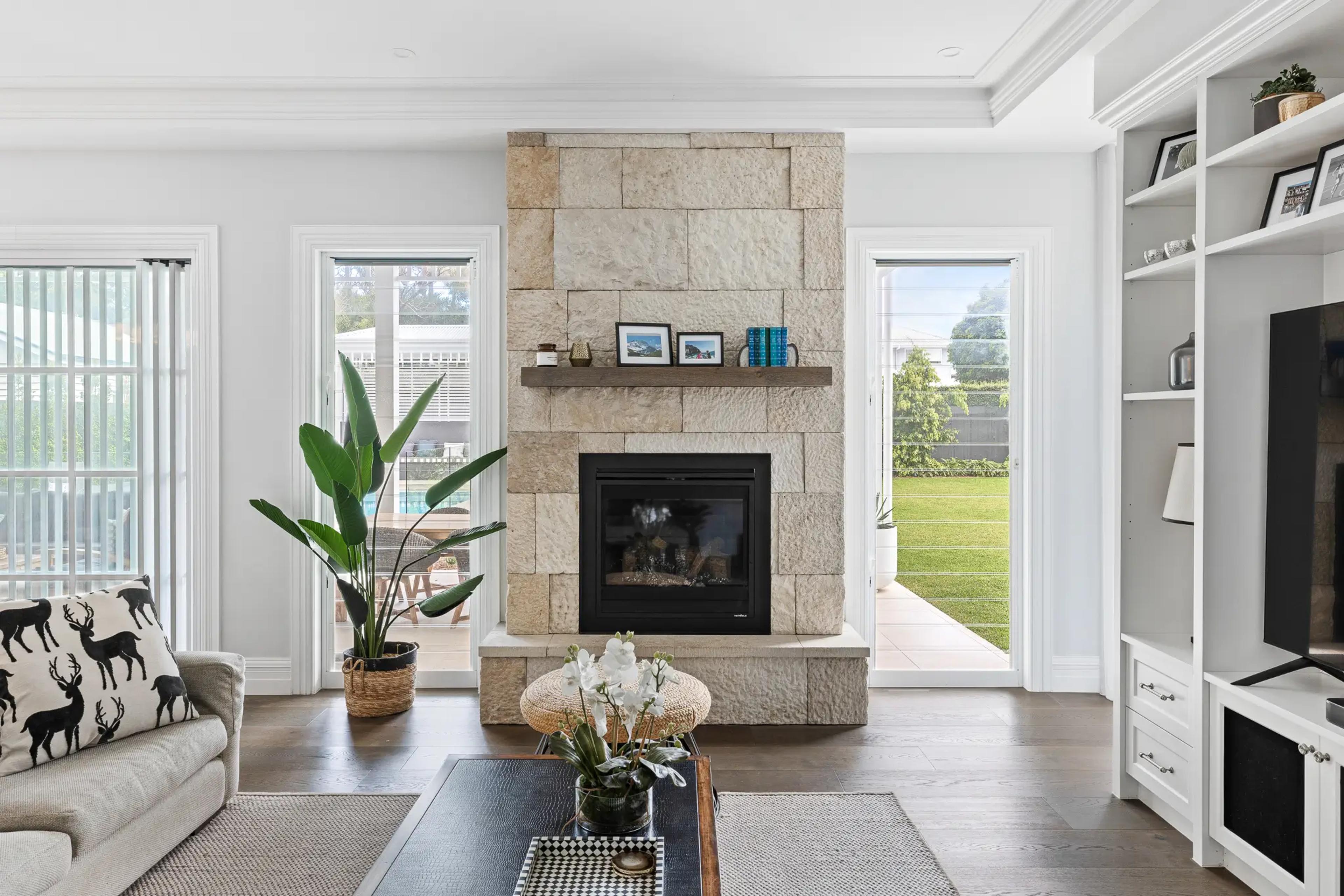 Living room with stacked stone gas fireplace and built in shelving