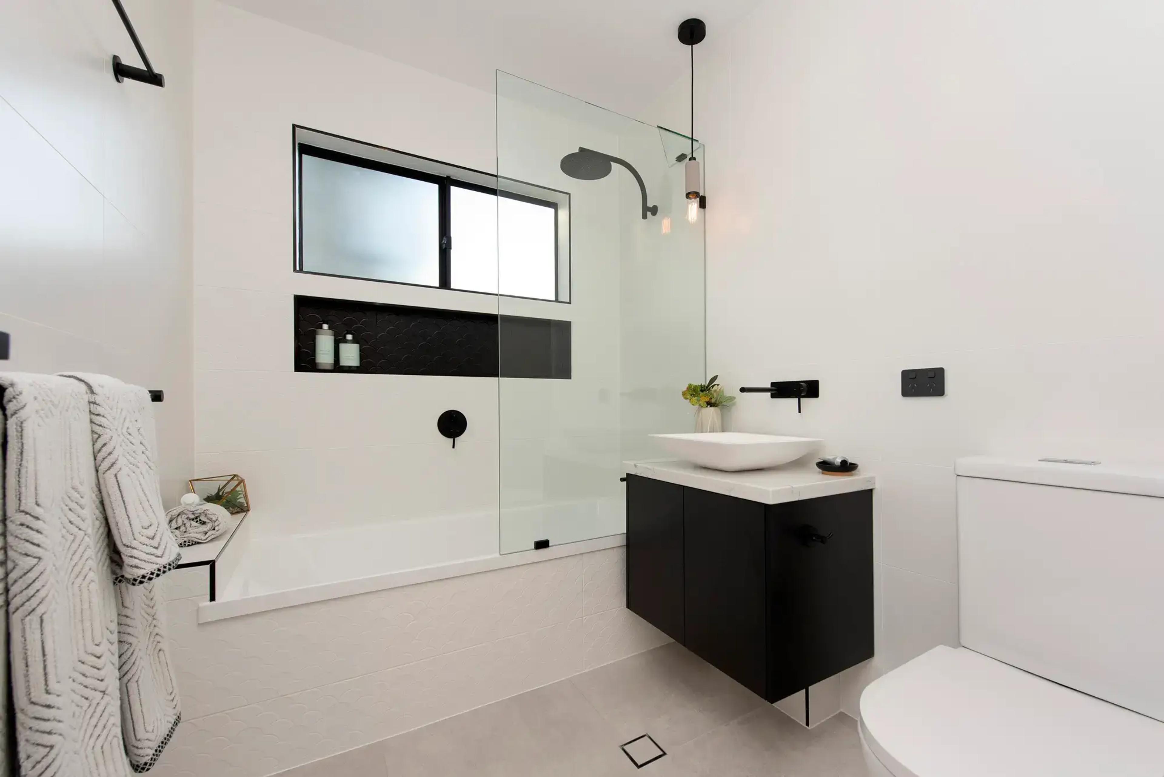 Bathroom with bathtub, shower and black vanity
