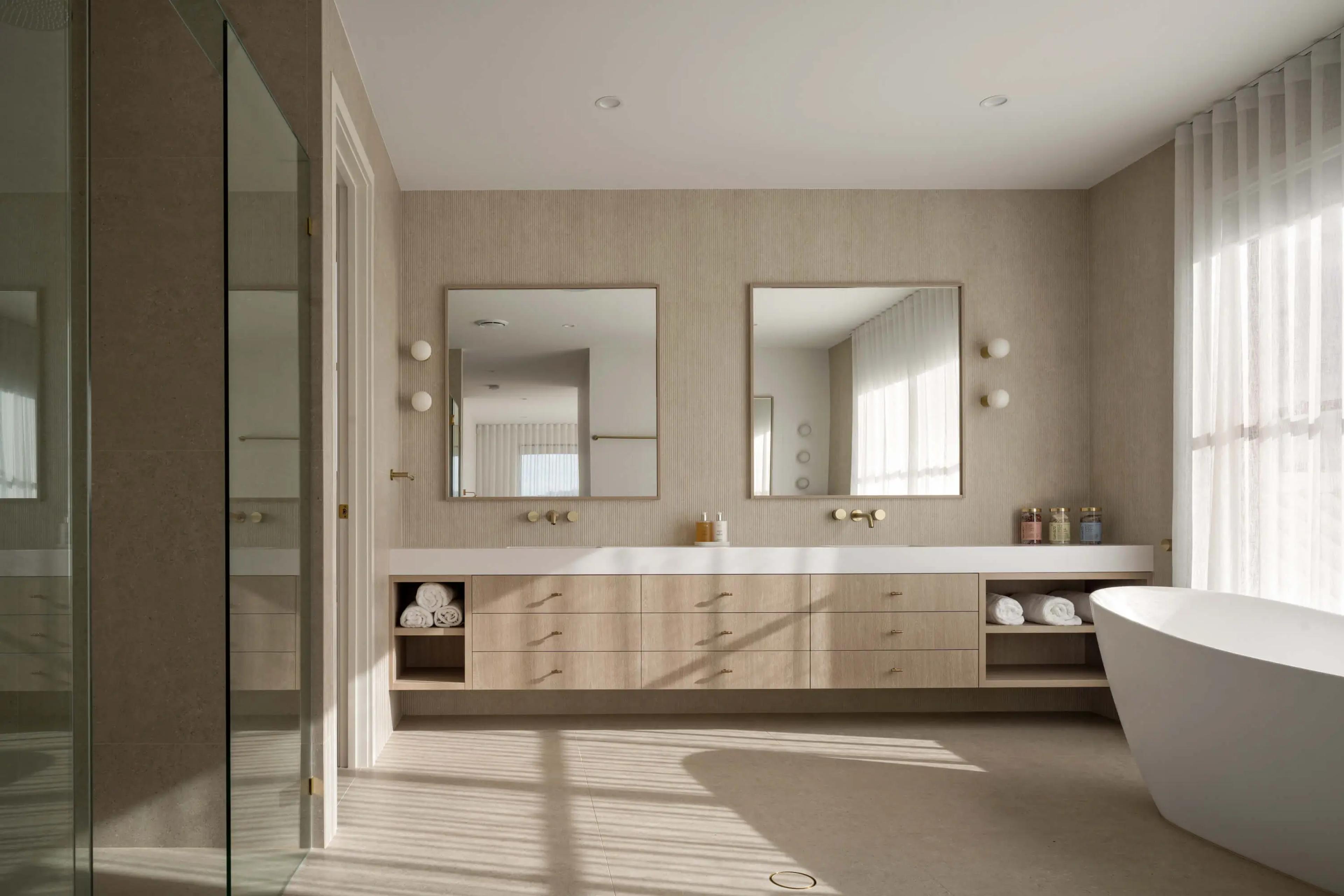 Bathroom with double vanity, twin mirrors and freestanding bath