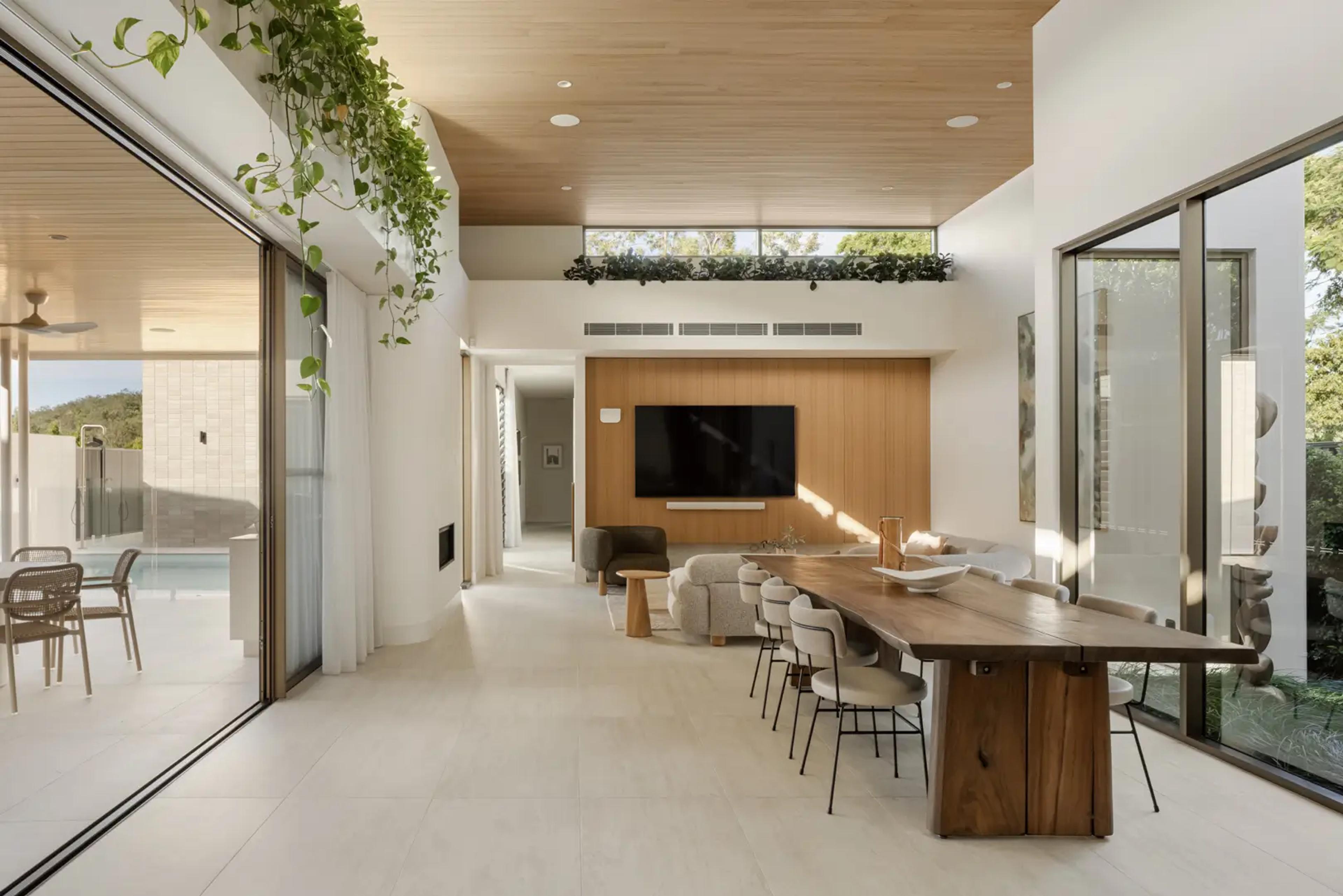 Dining and living space opening to pool through glass doors