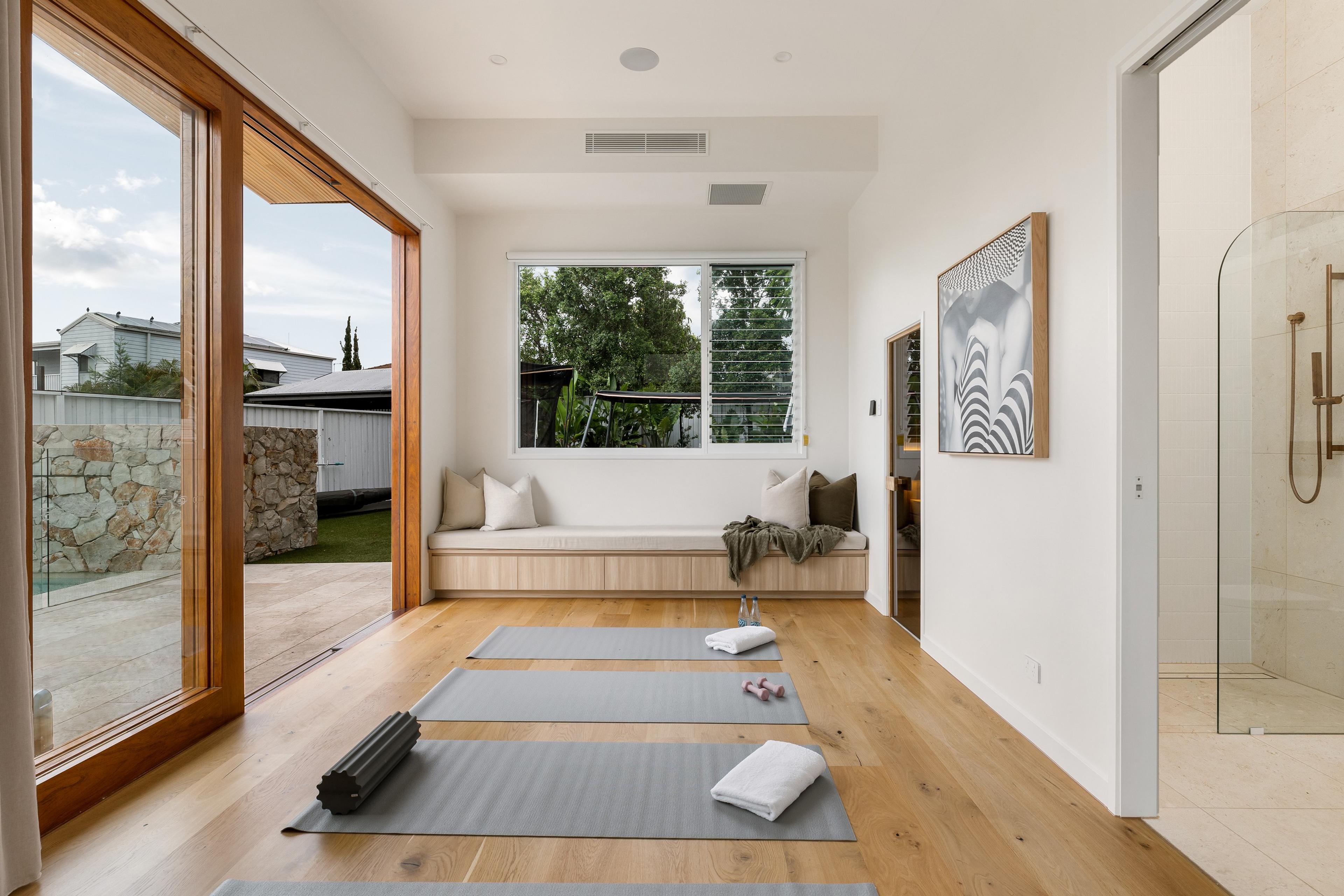Yoga room with timber bench seat and glass doors to garden