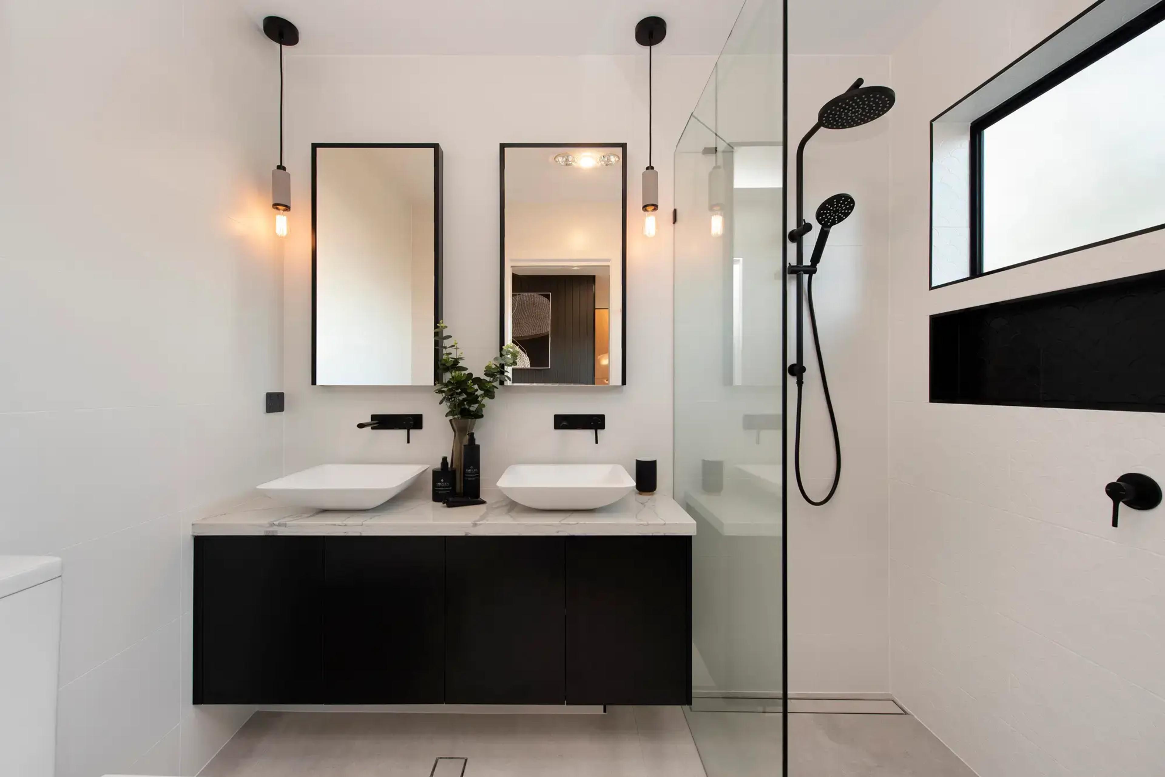 Bathroom with twin basins and black framed mirrors