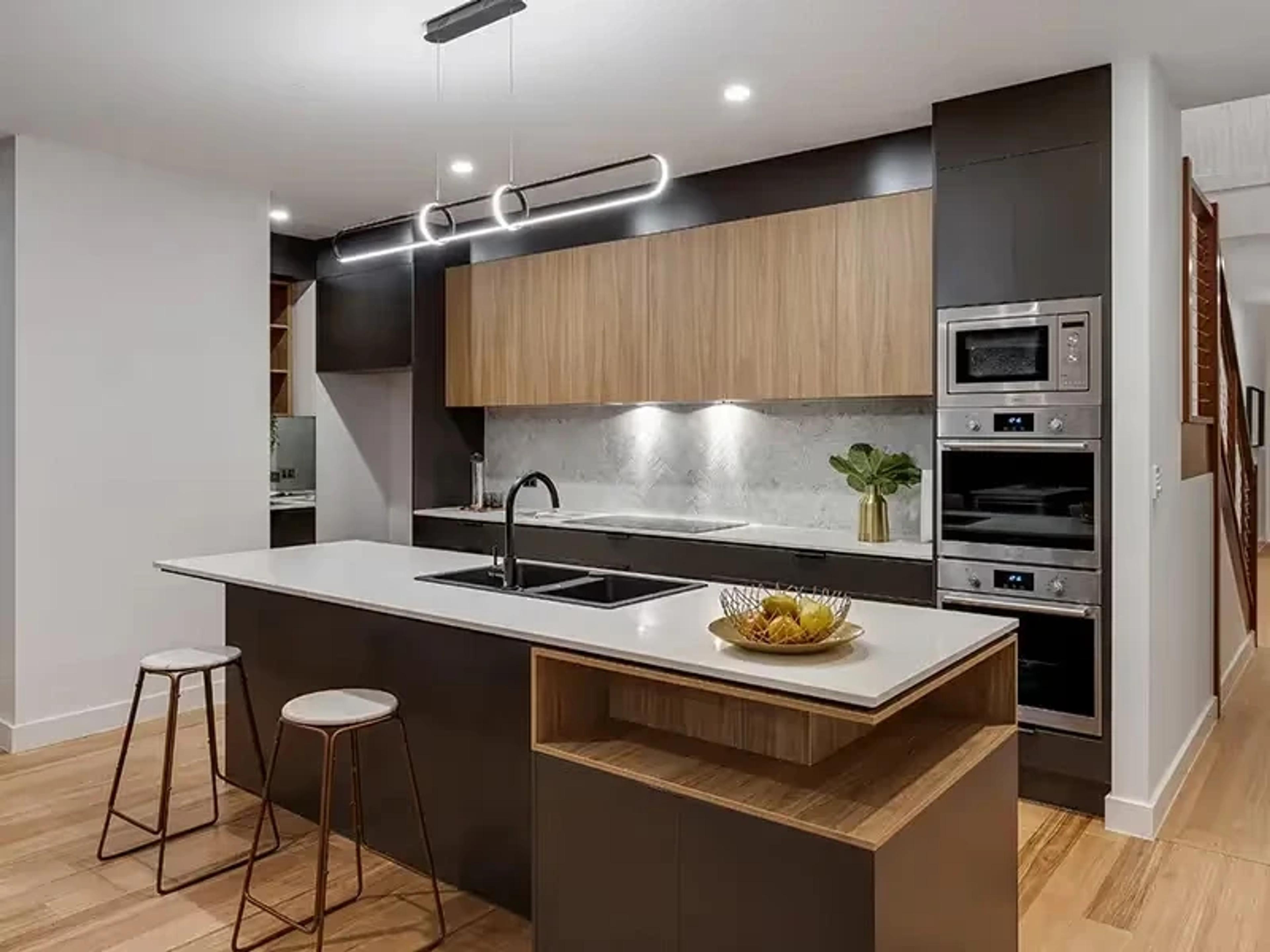 Modern kitchen with timber cabinetry and stone island bench