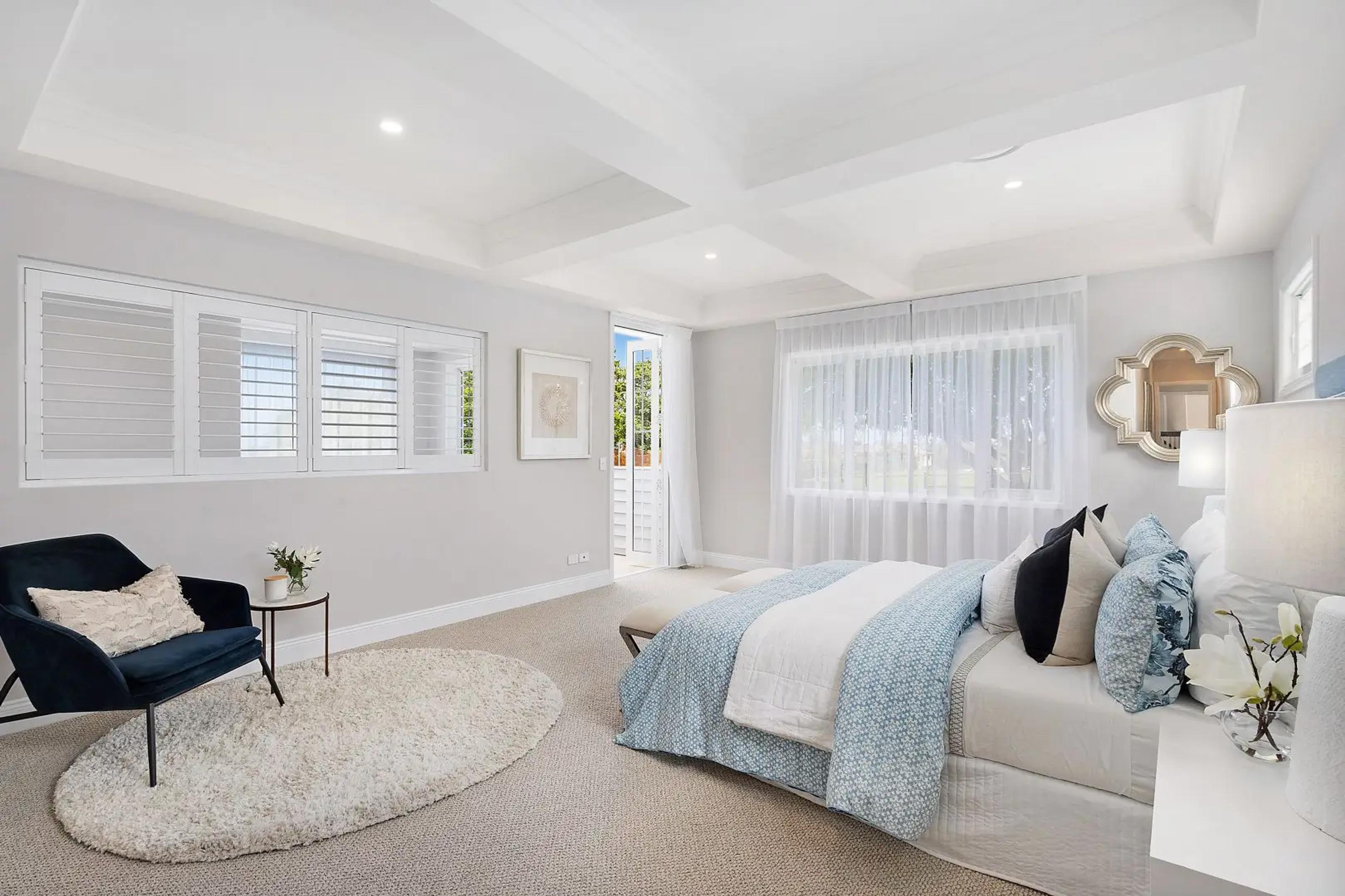 Main bedroom with coffered ceiling and balcony access