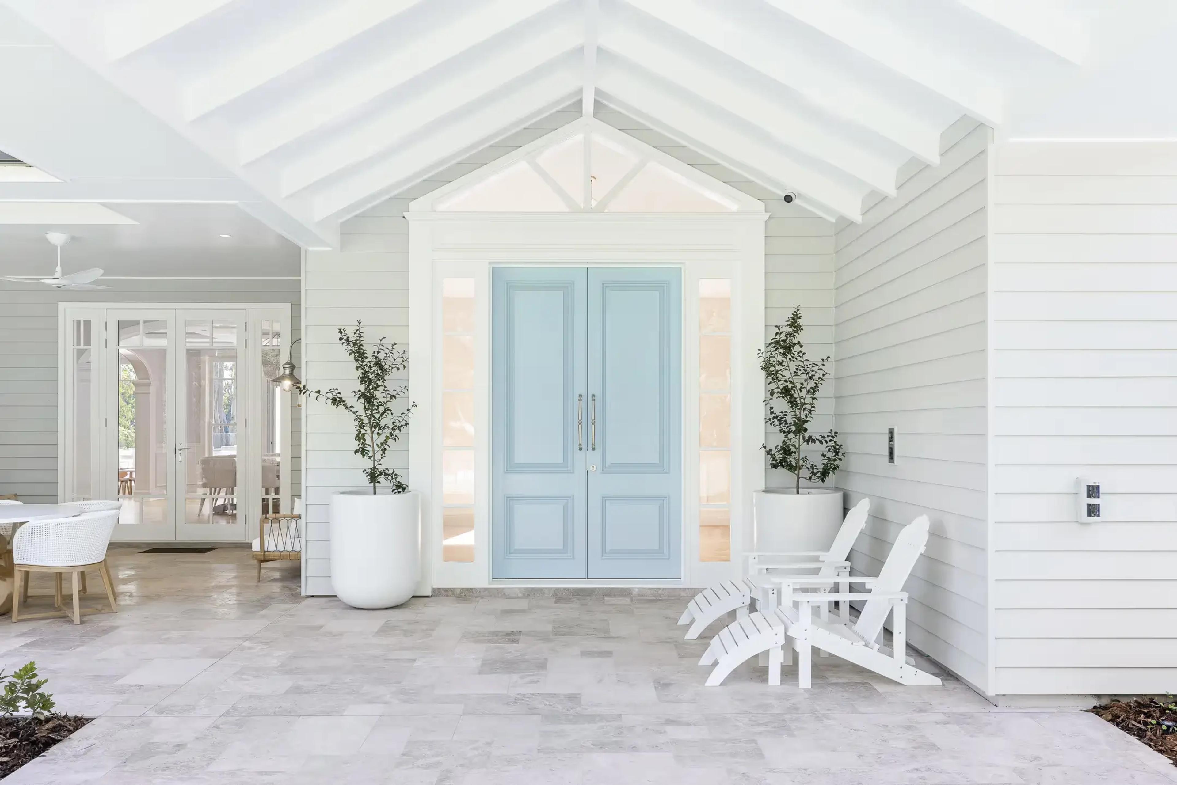 Pastel blue double front doors on a luxury New England style home