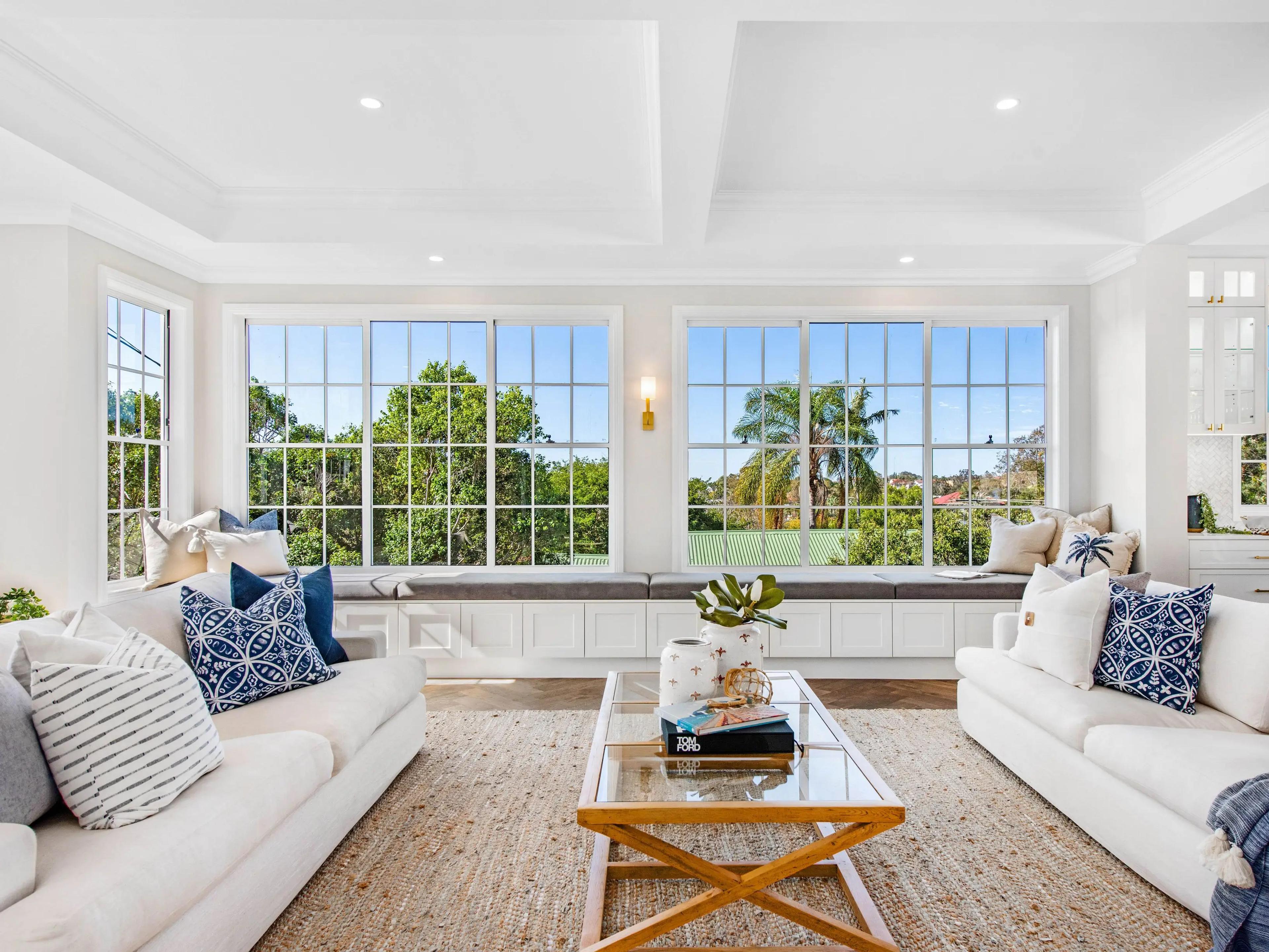 Living room with two white sofas and window seat