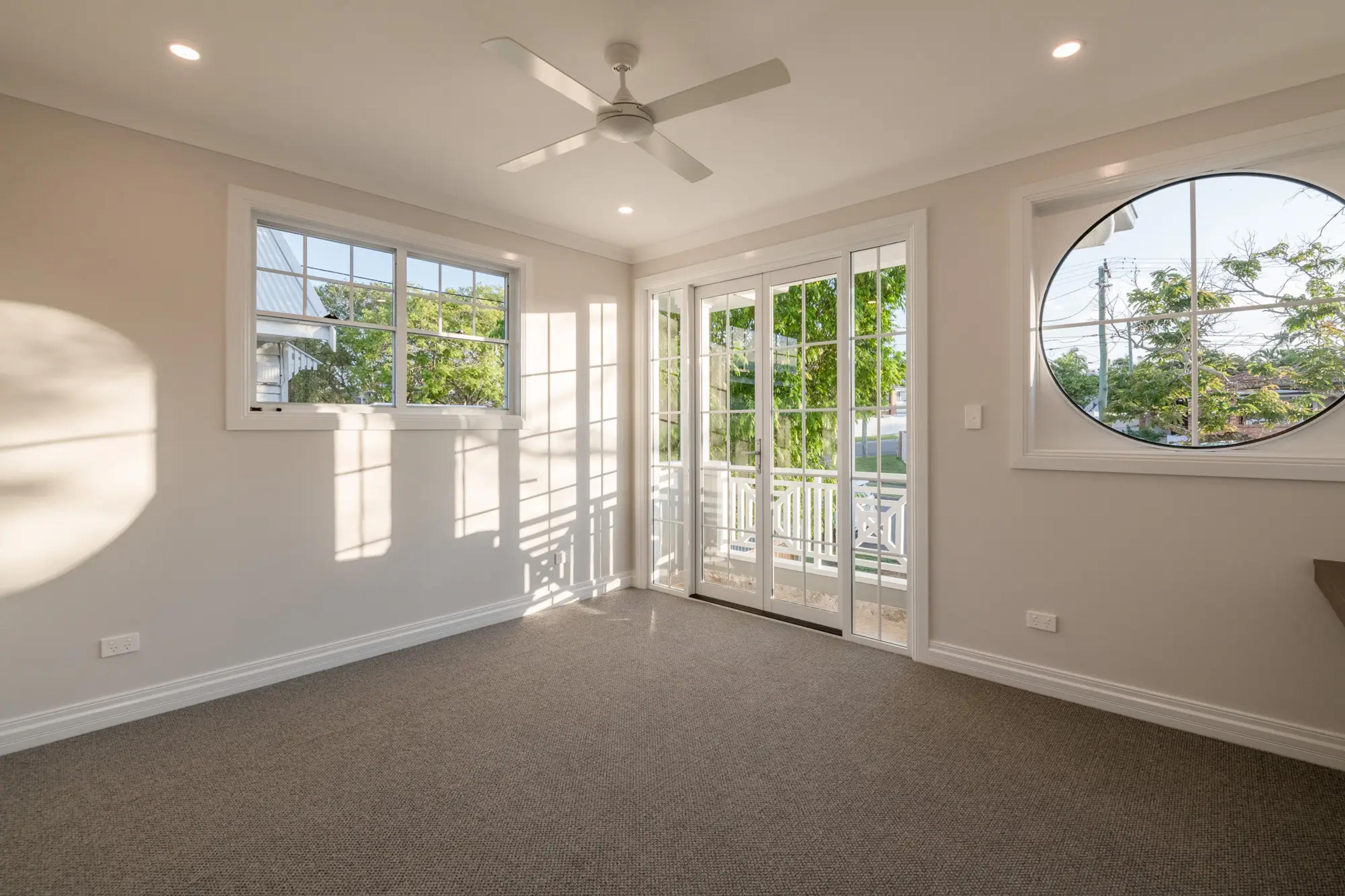 Bedroom with balcony doors and round porthole window