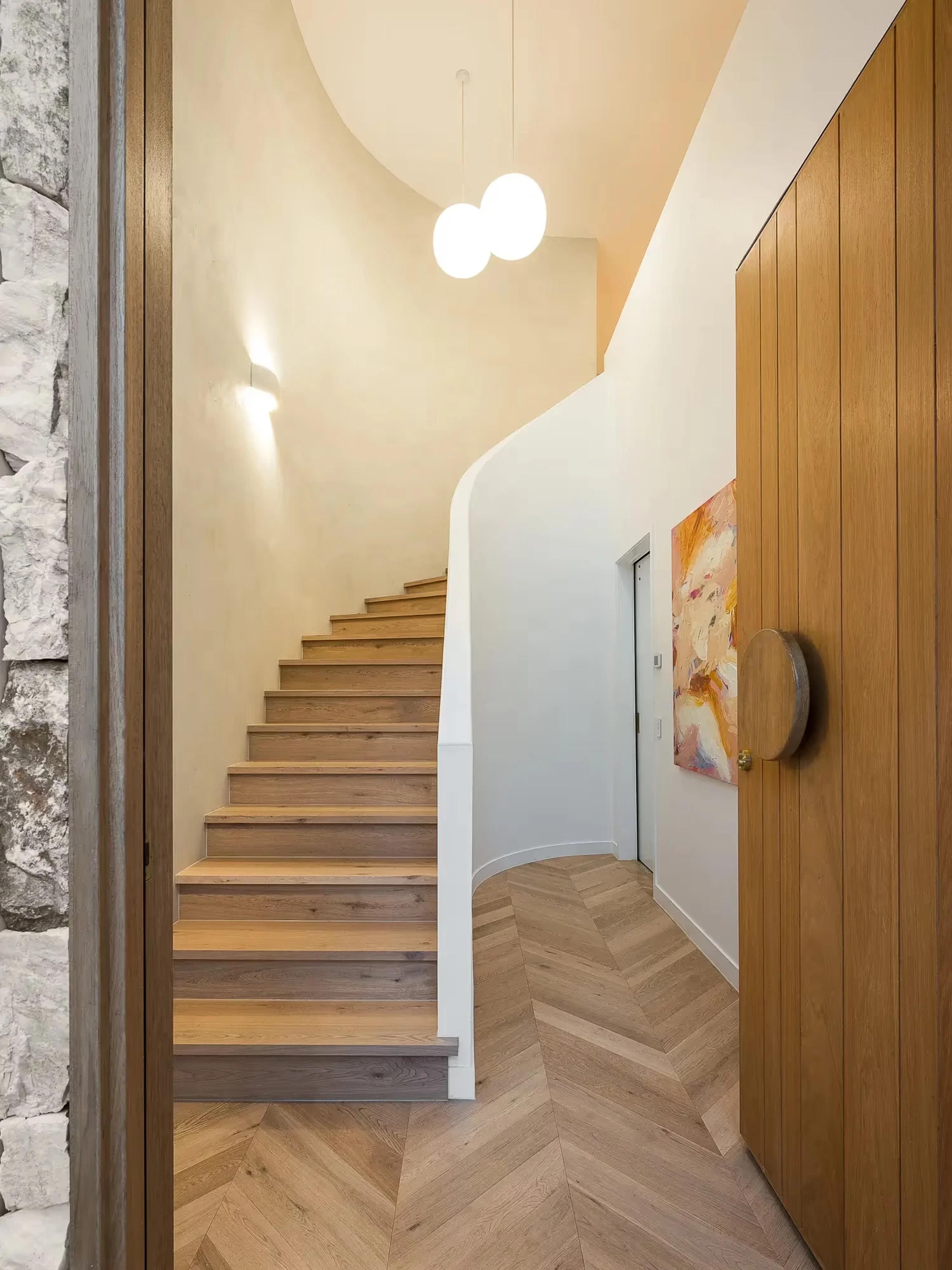 Curved timber staircase with pendant lights