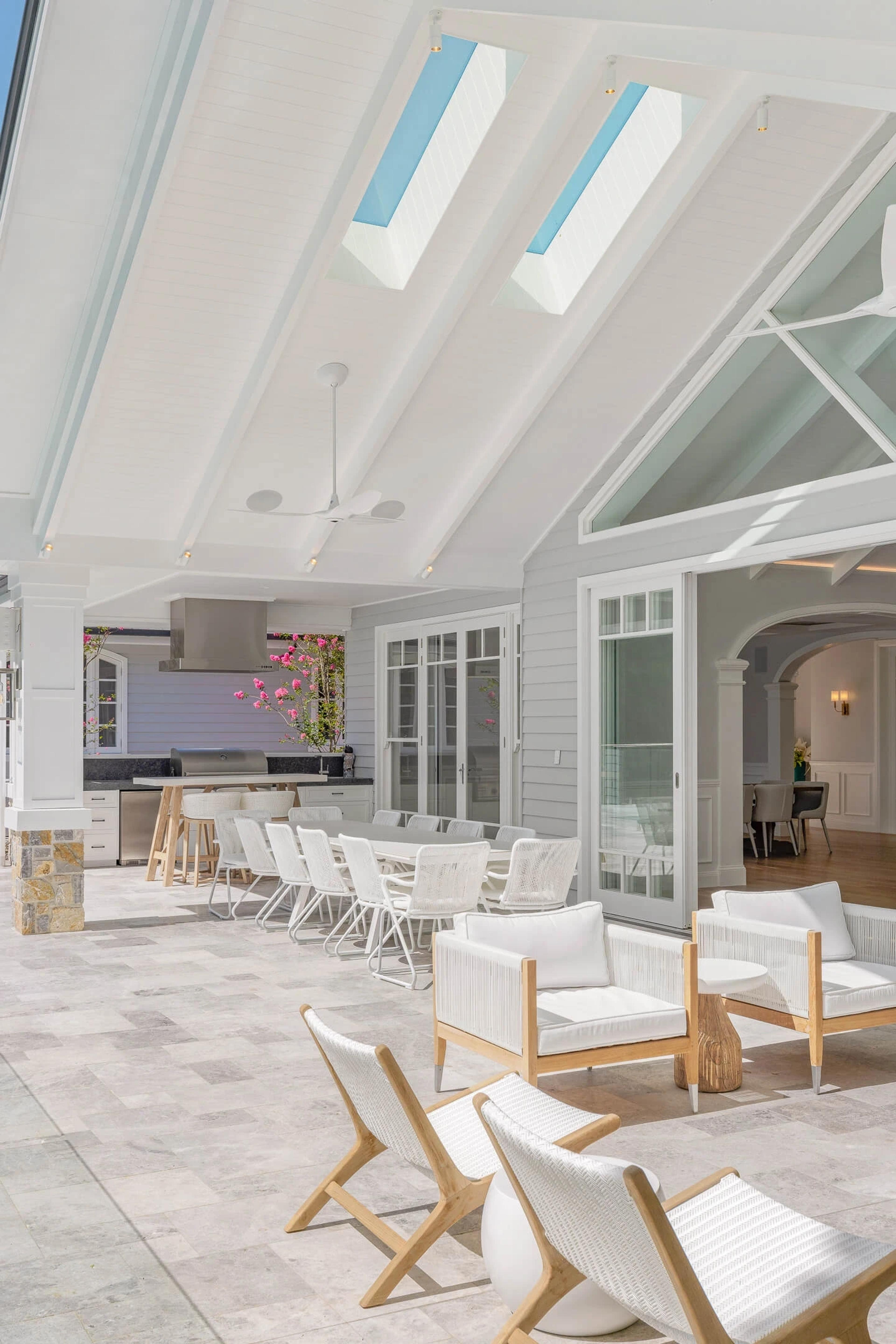Alfresco outdoor kitchen and dining under vaulted skylight ceiling