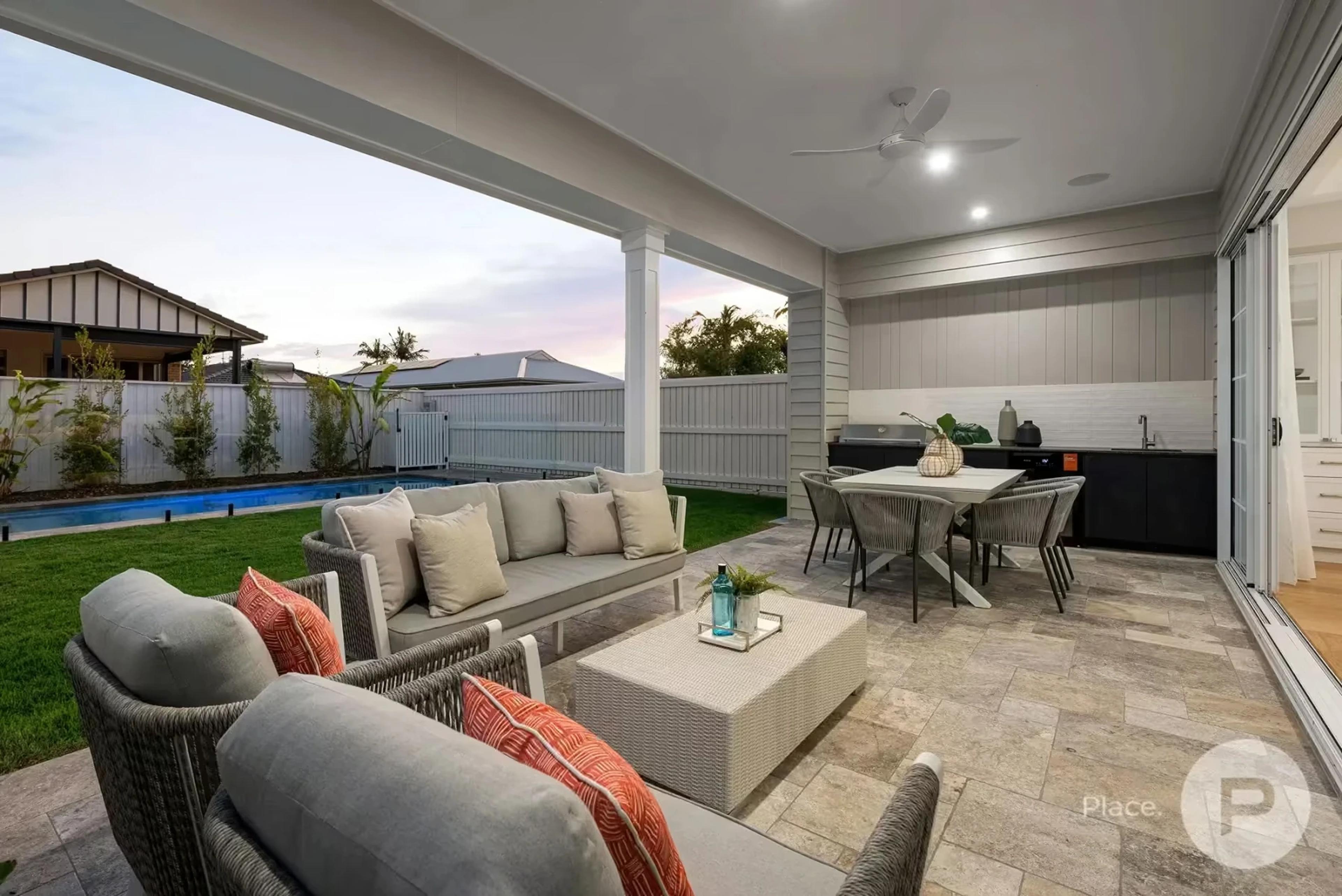 Covered outdoor lounge and dining beside swimming pool