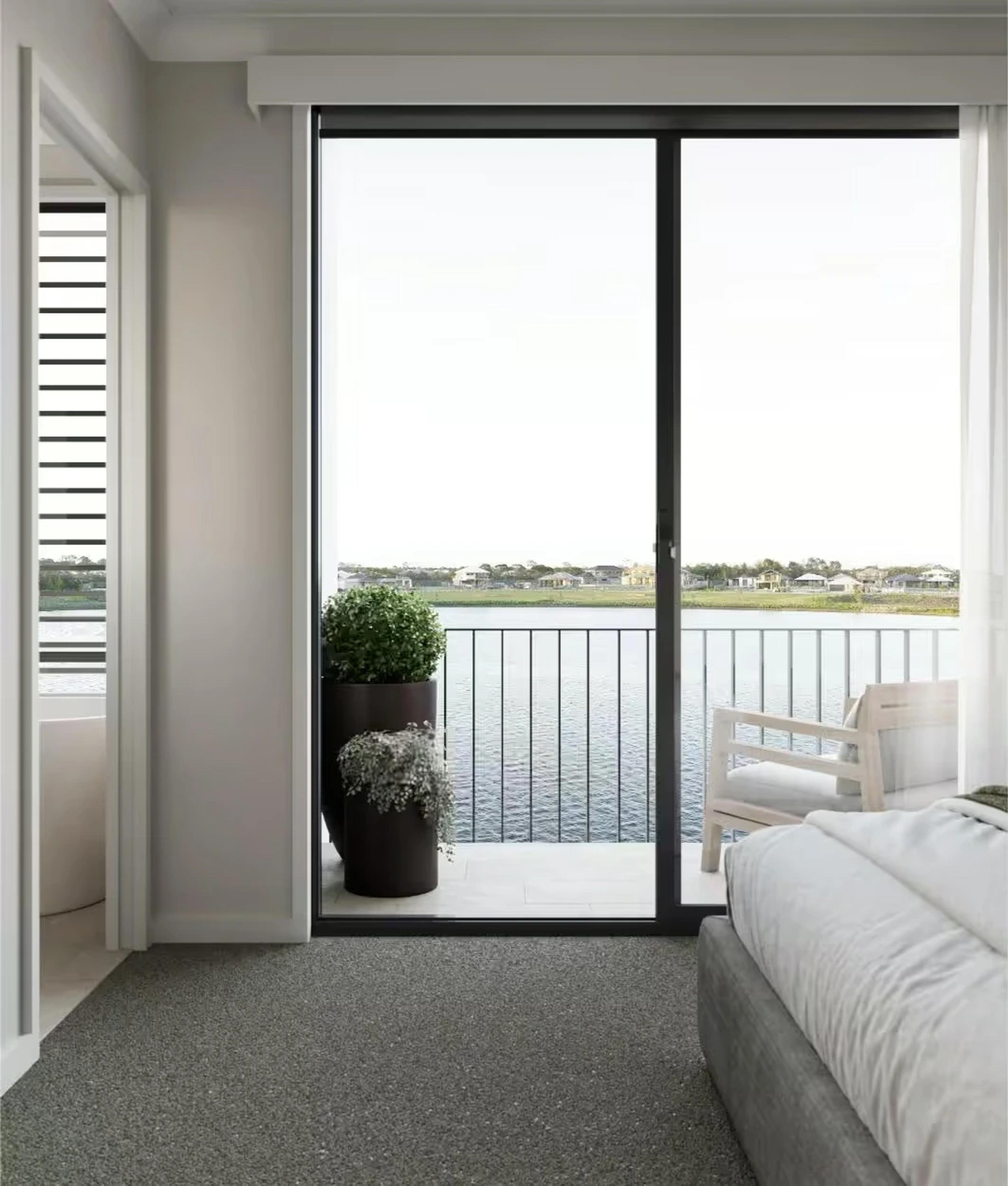 Bedroom with sliding doors opening onto balcony over the lake