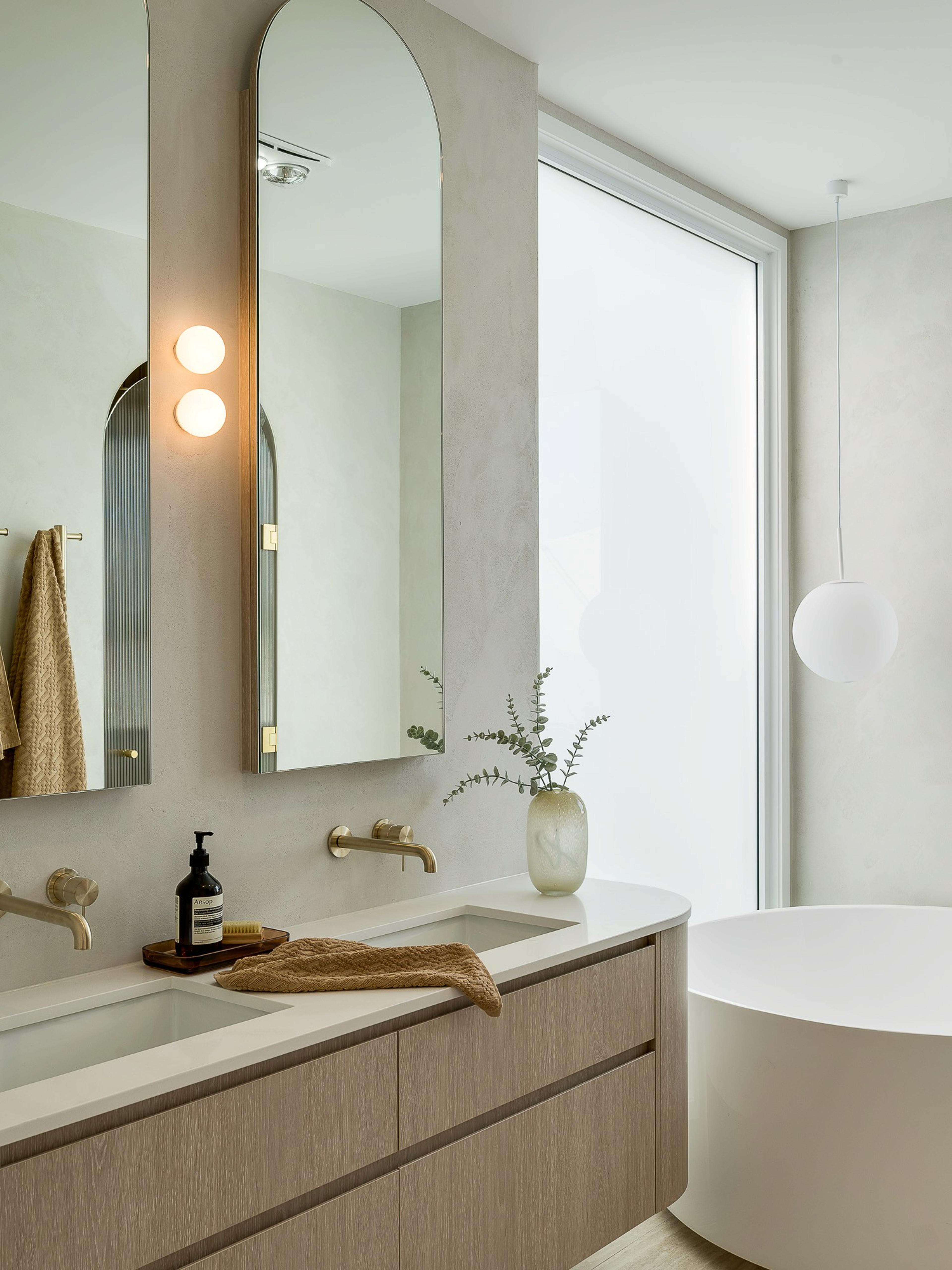 Ensuite vanity with arched mirrors and bath