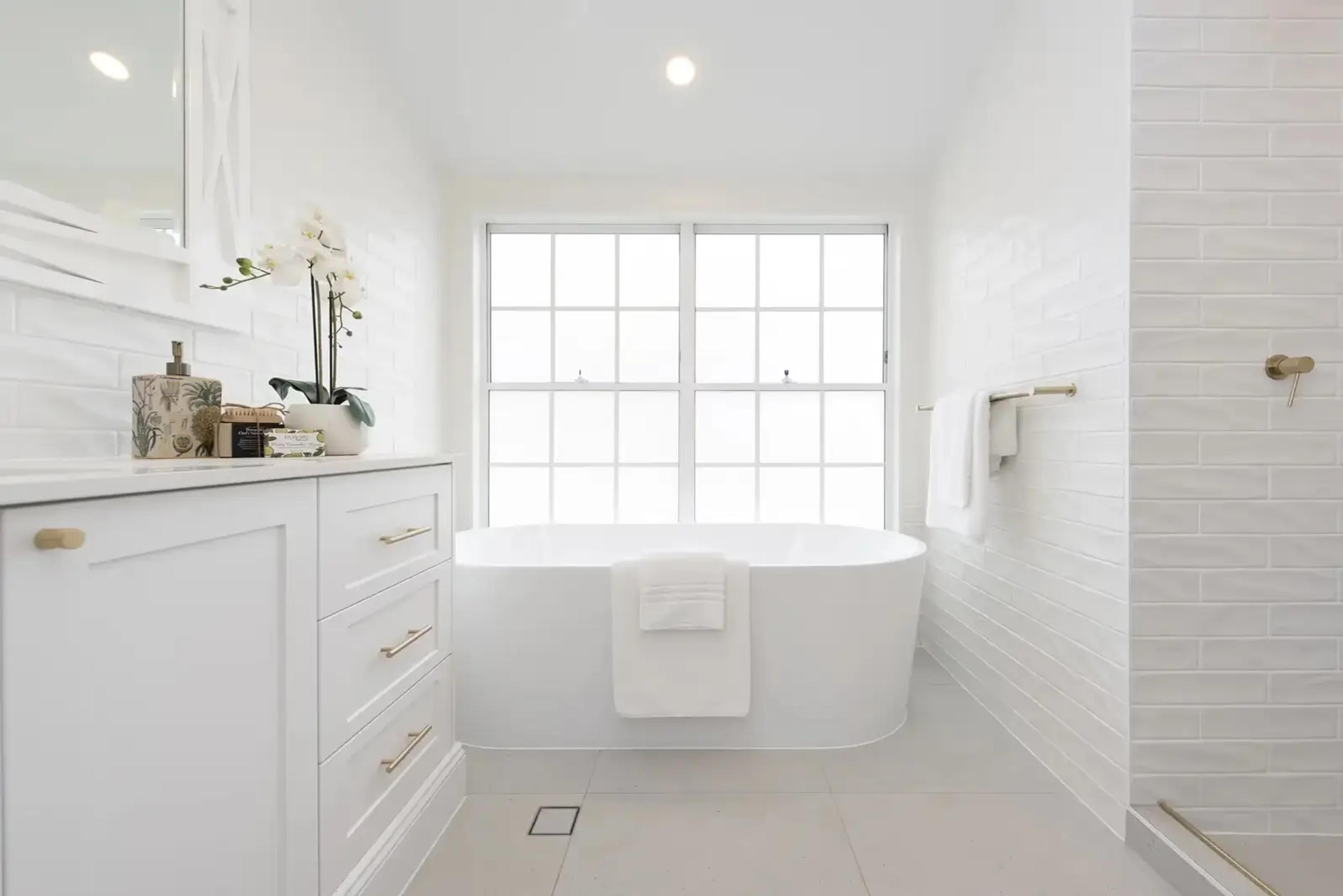White bathroom with freestanding bath, subway tiles and shower