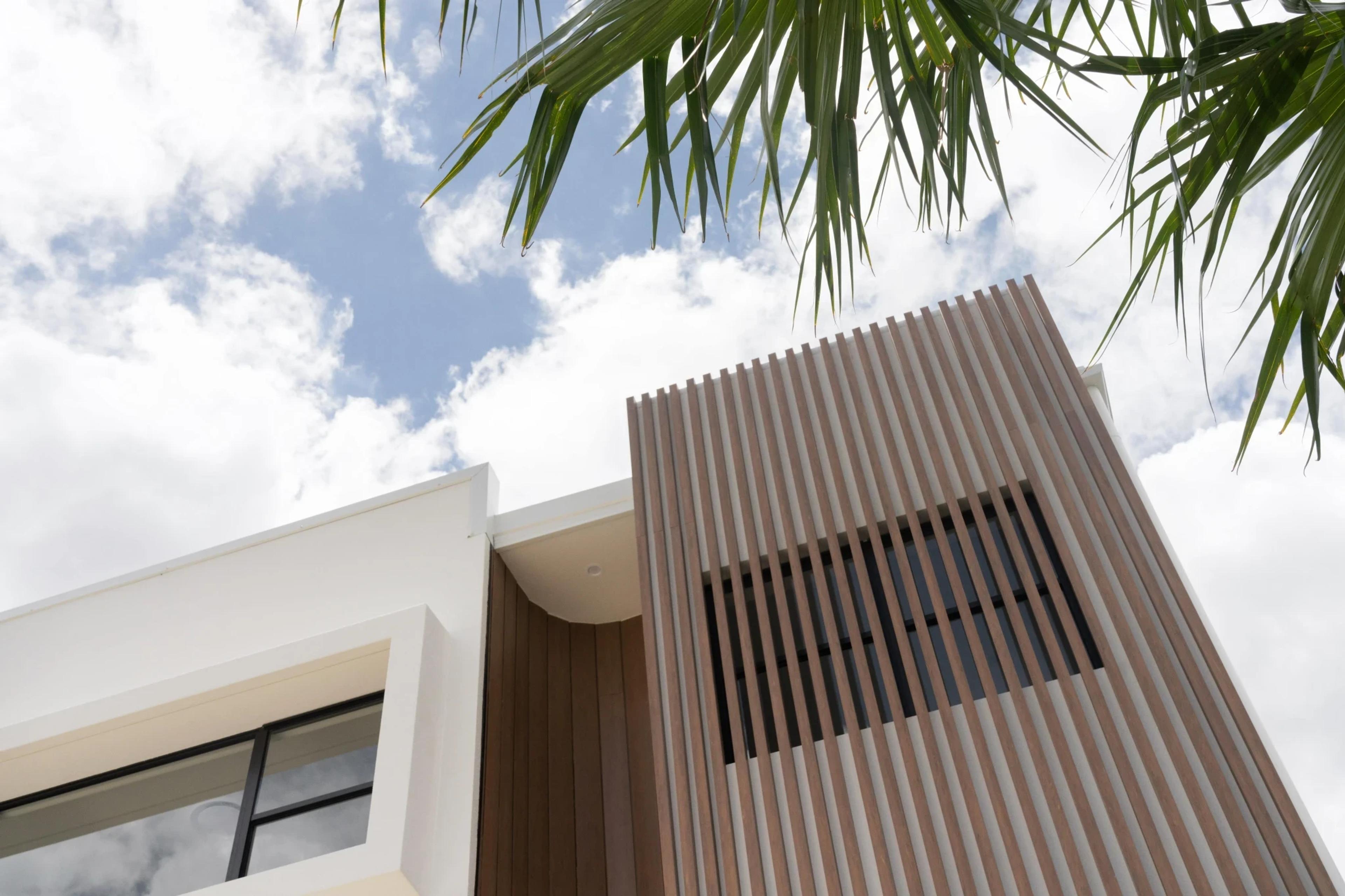 Detail of timber batten screen and white render upper facade