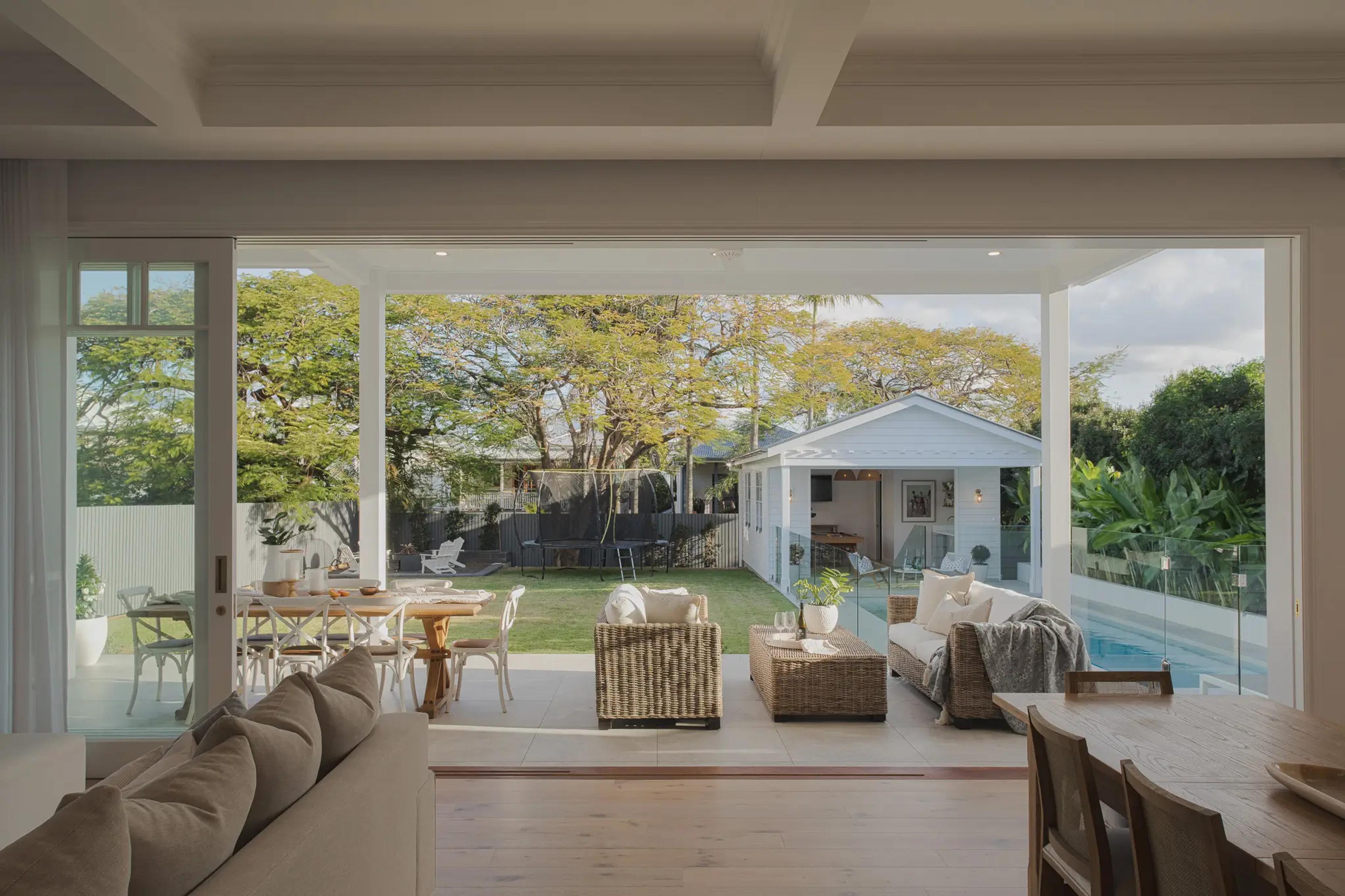 Open plan living opening to covered patio, lawn and pool