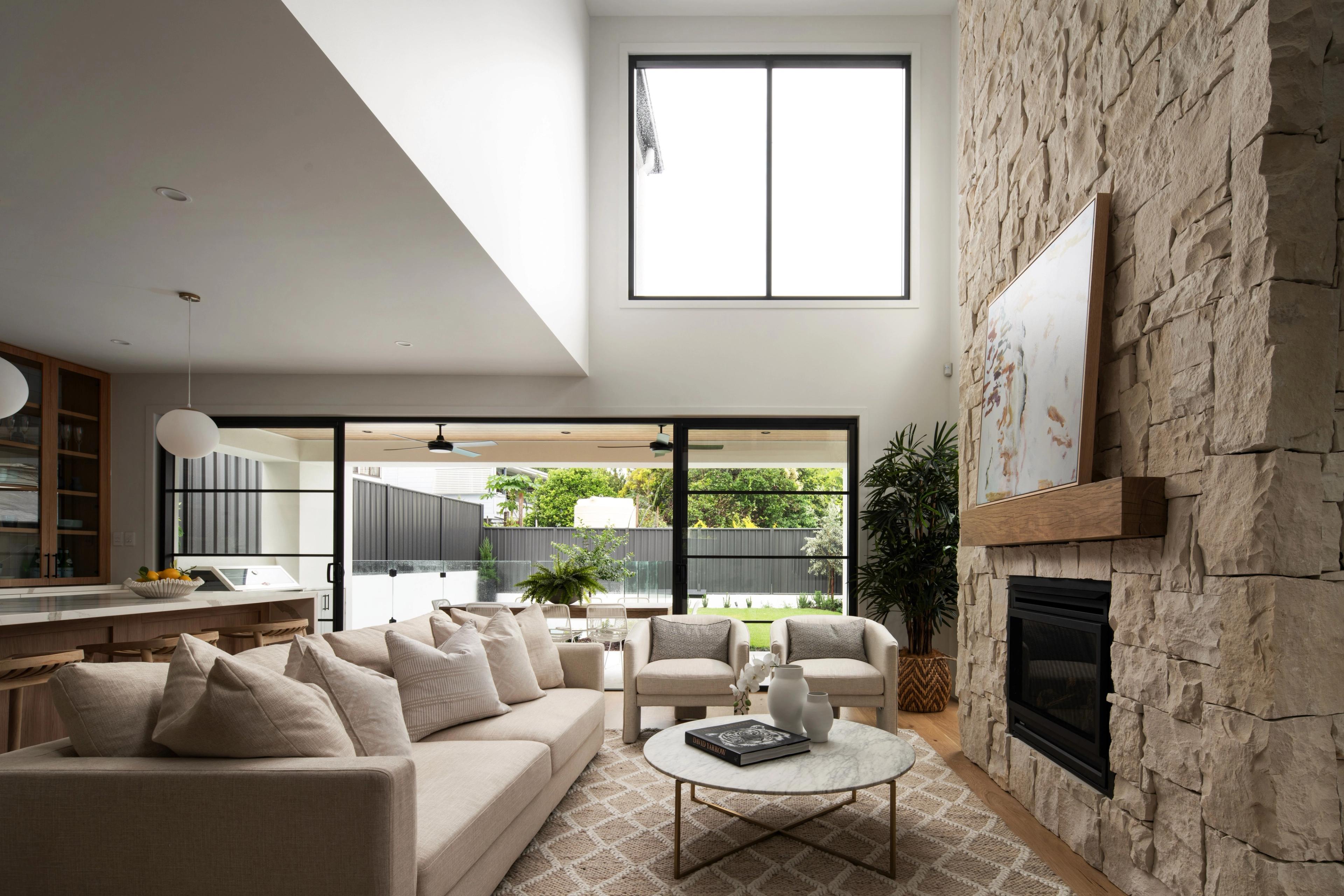 Living room with tall stone fireplace wall and linen sofa