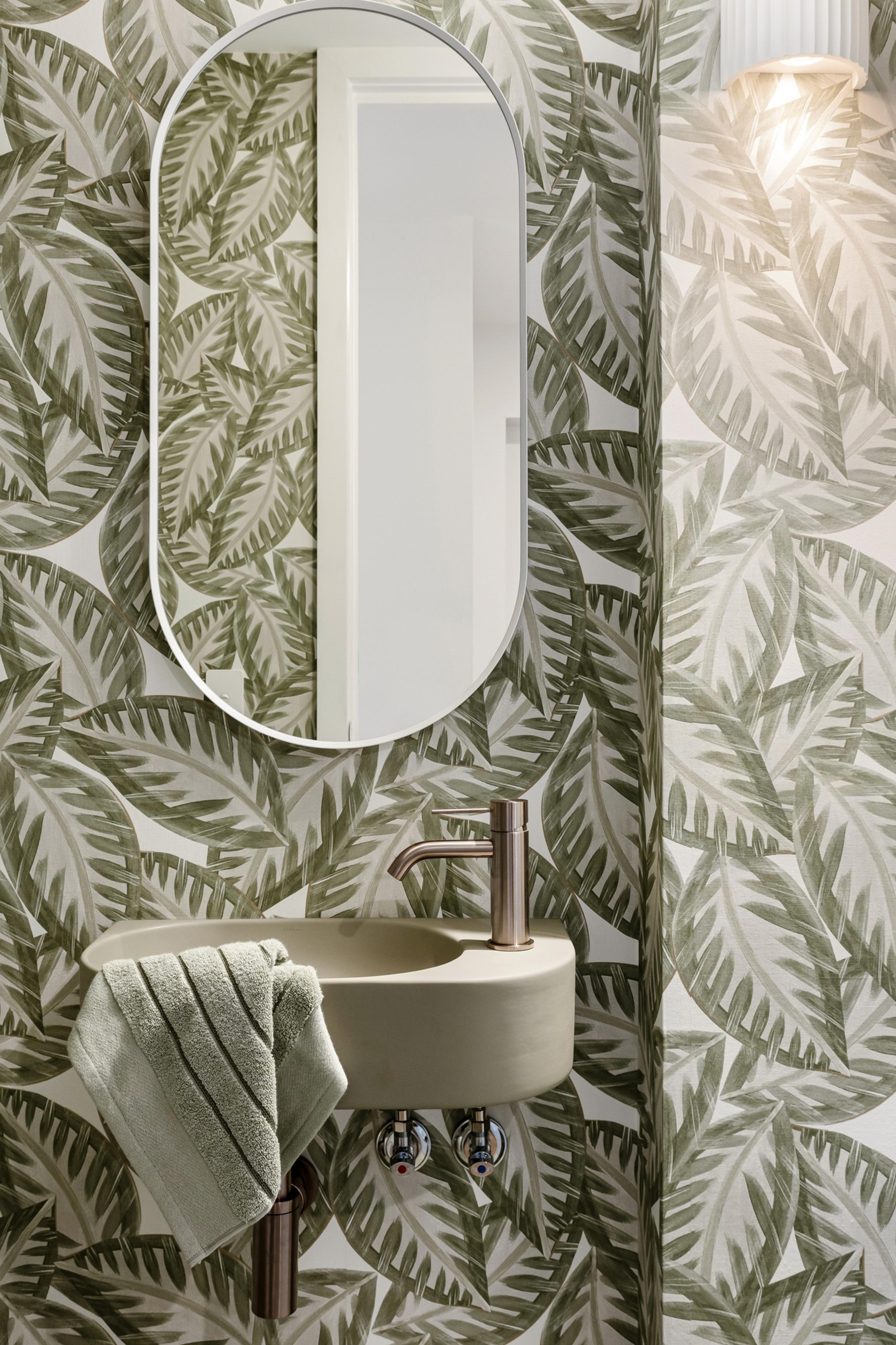 Powder room with leafy wallpaper and wall mounted basin