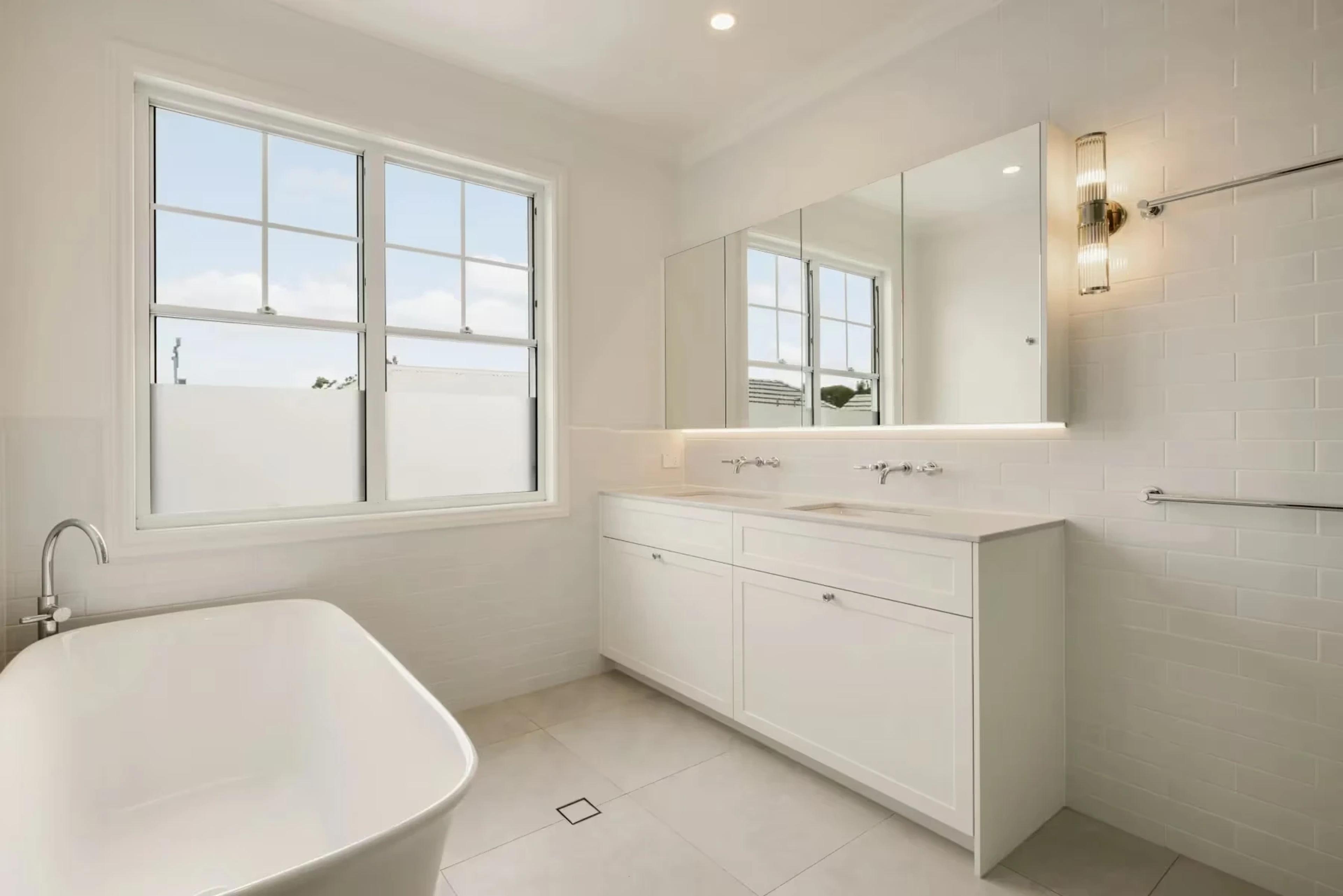 White bathroom with freestanding bath and double vanity
