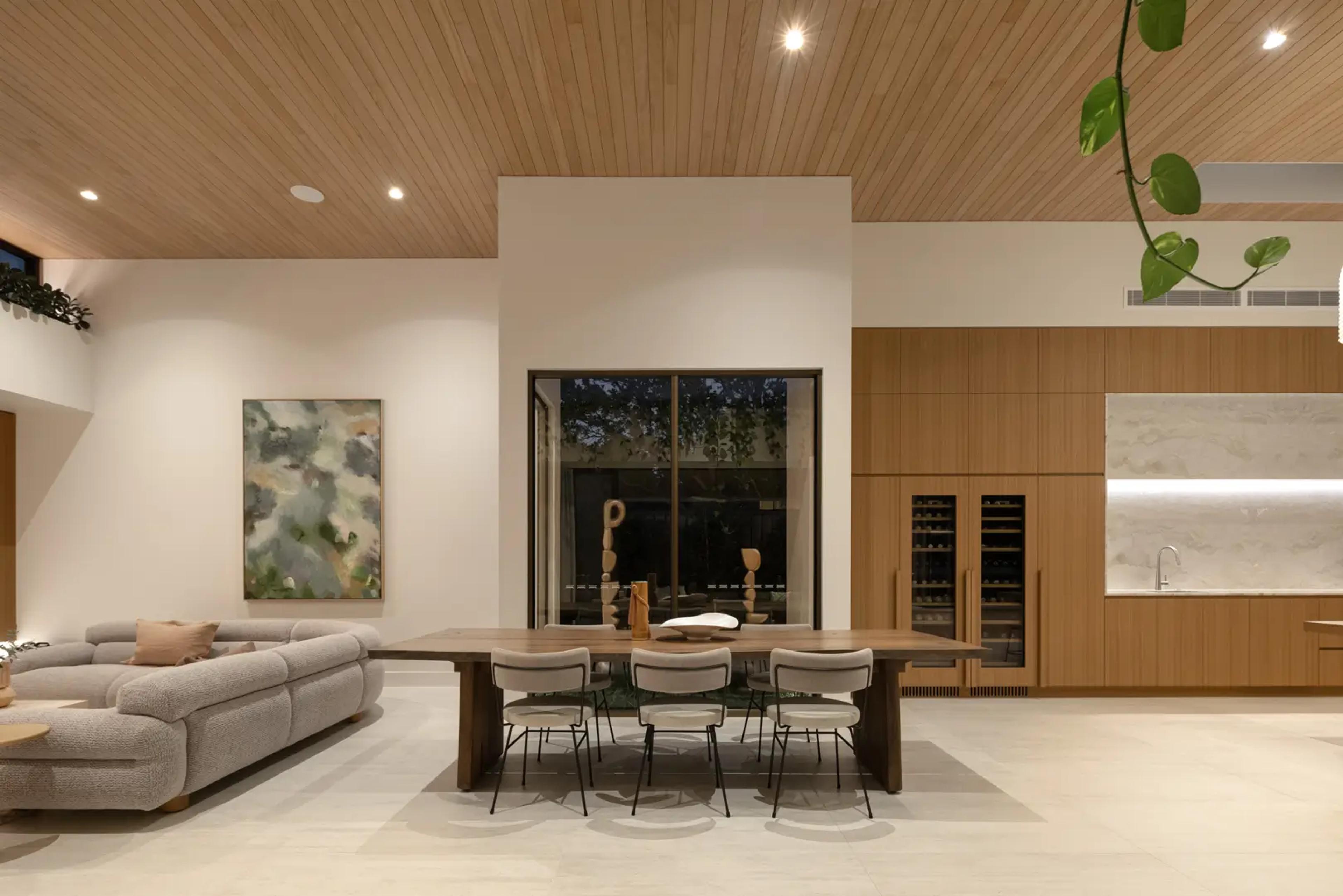 Living and dining area with timber ceiling and artwork