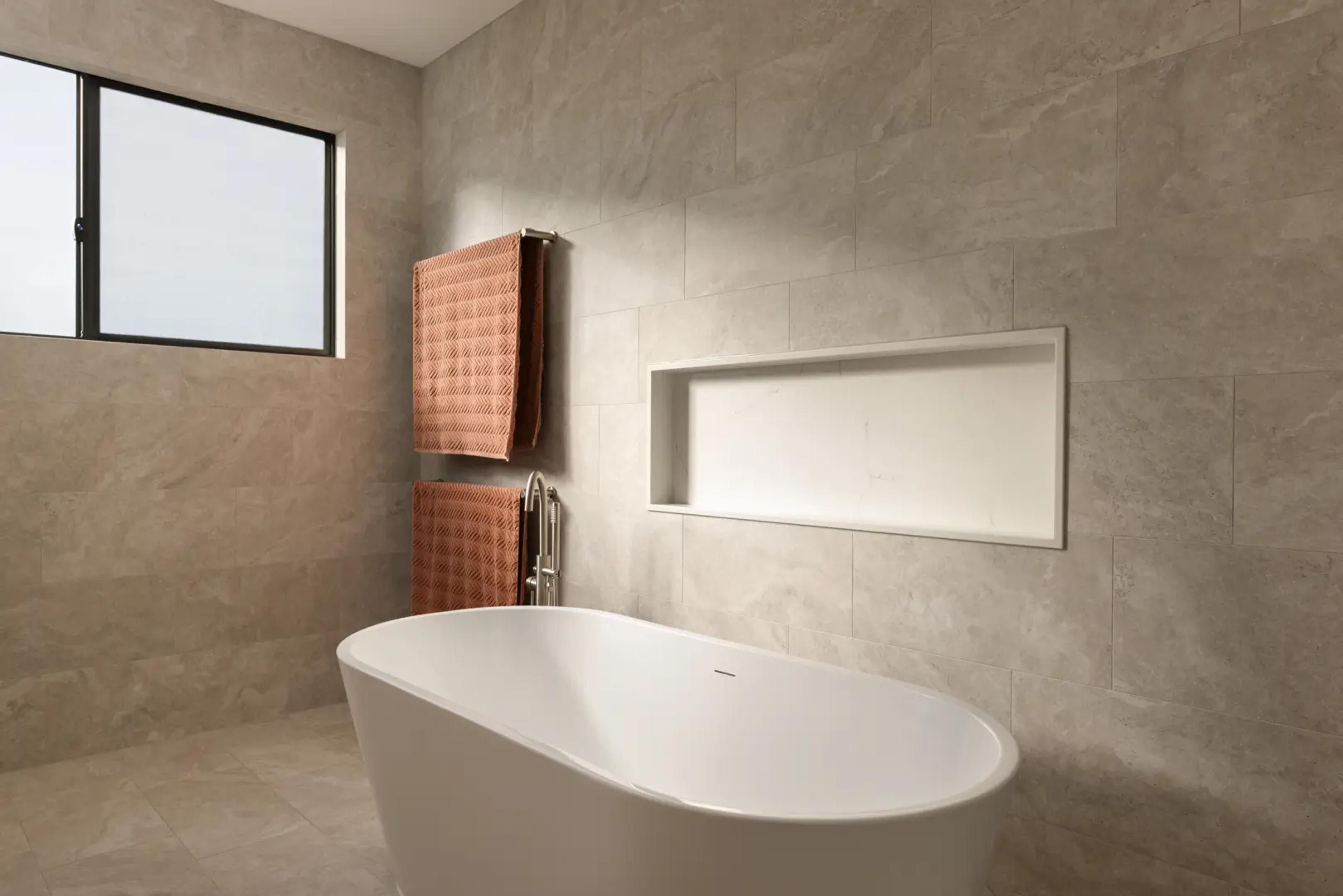 Bathroom with freestanding bath and tiled recessed niche