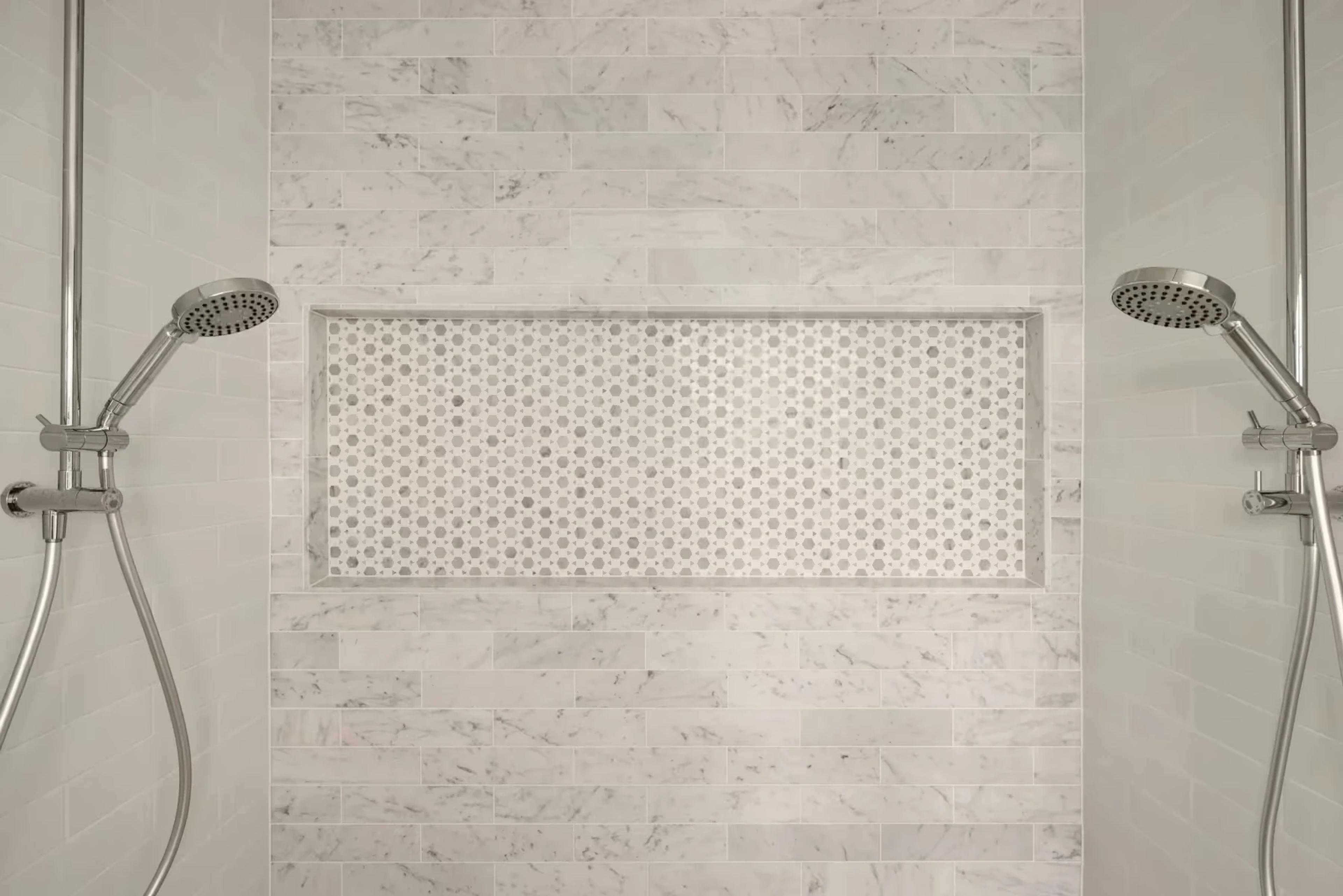 Marble tiled shower with twin rail showers and niche