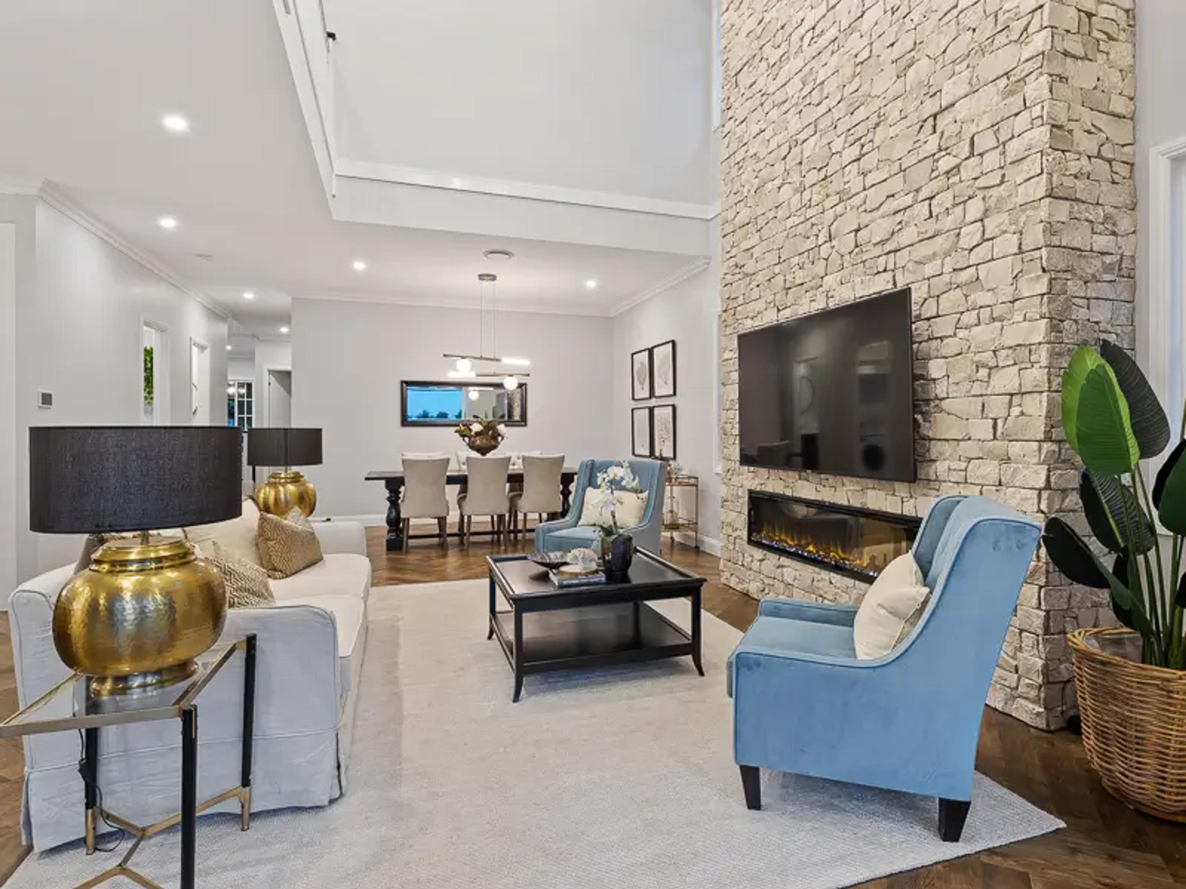 Living room with stone feature fireplace and blue armchairs
