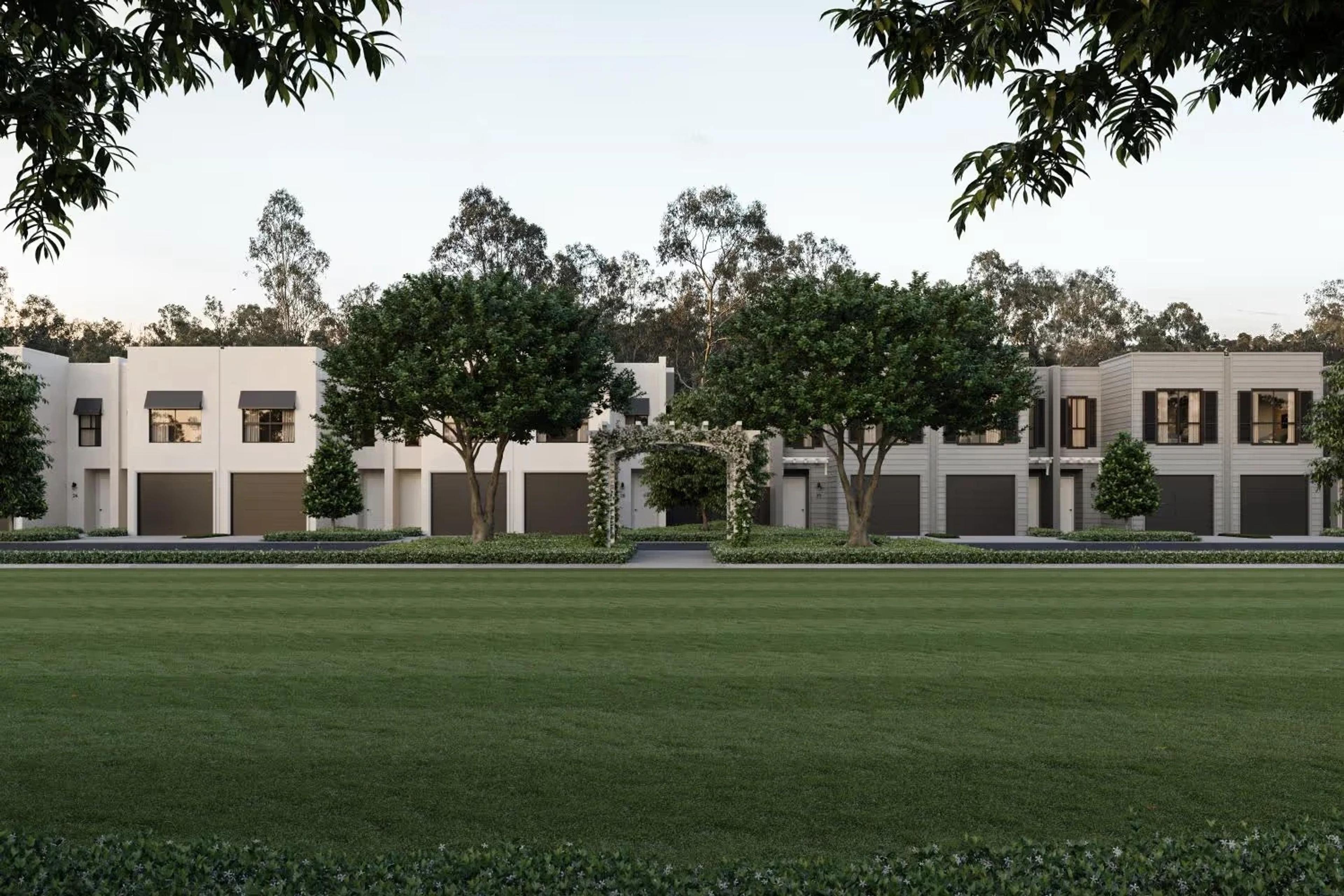 White townhouse row viewed across a manicured lawn
