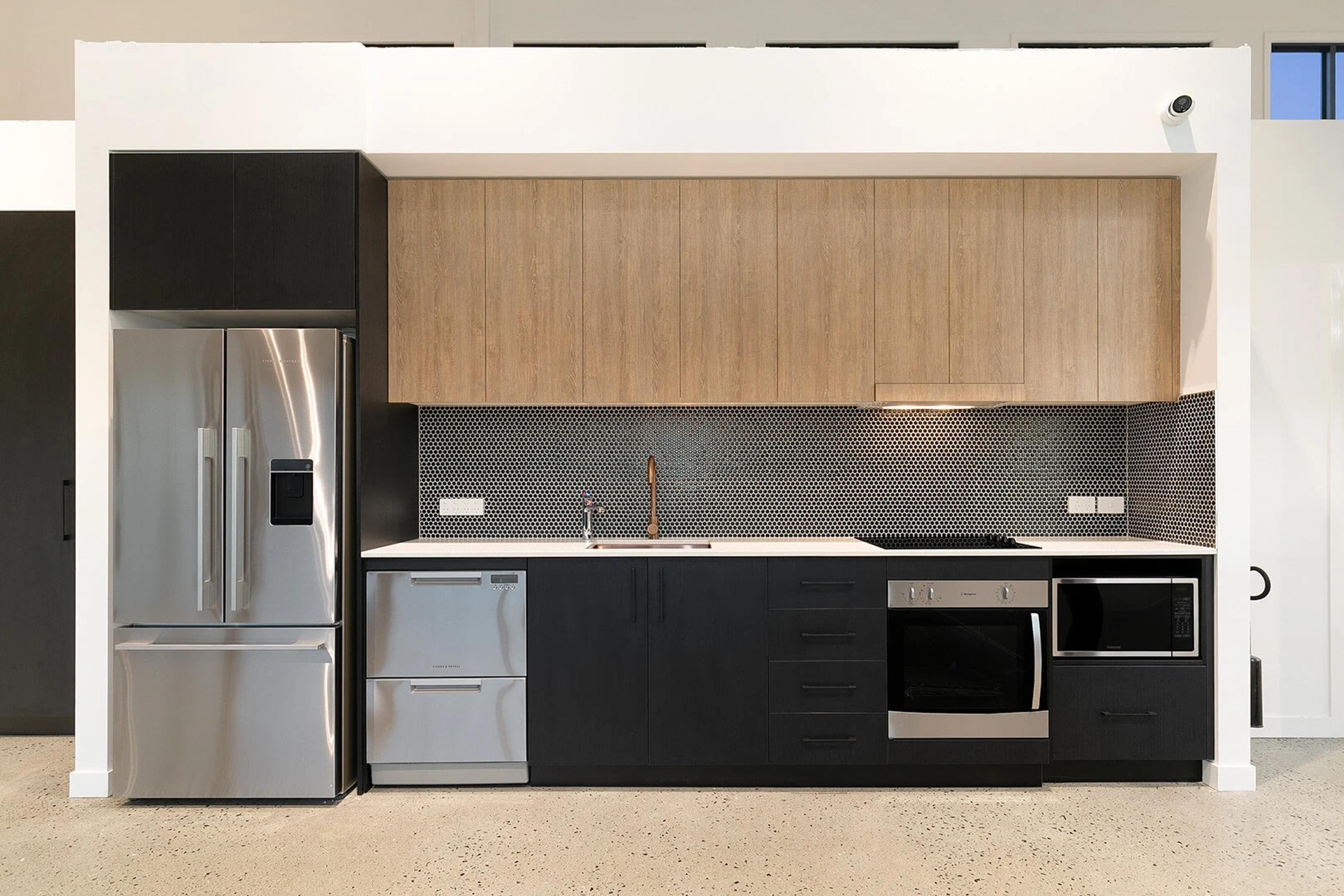 Kitchen with timber cabinets, stainless appliances and black joinery
