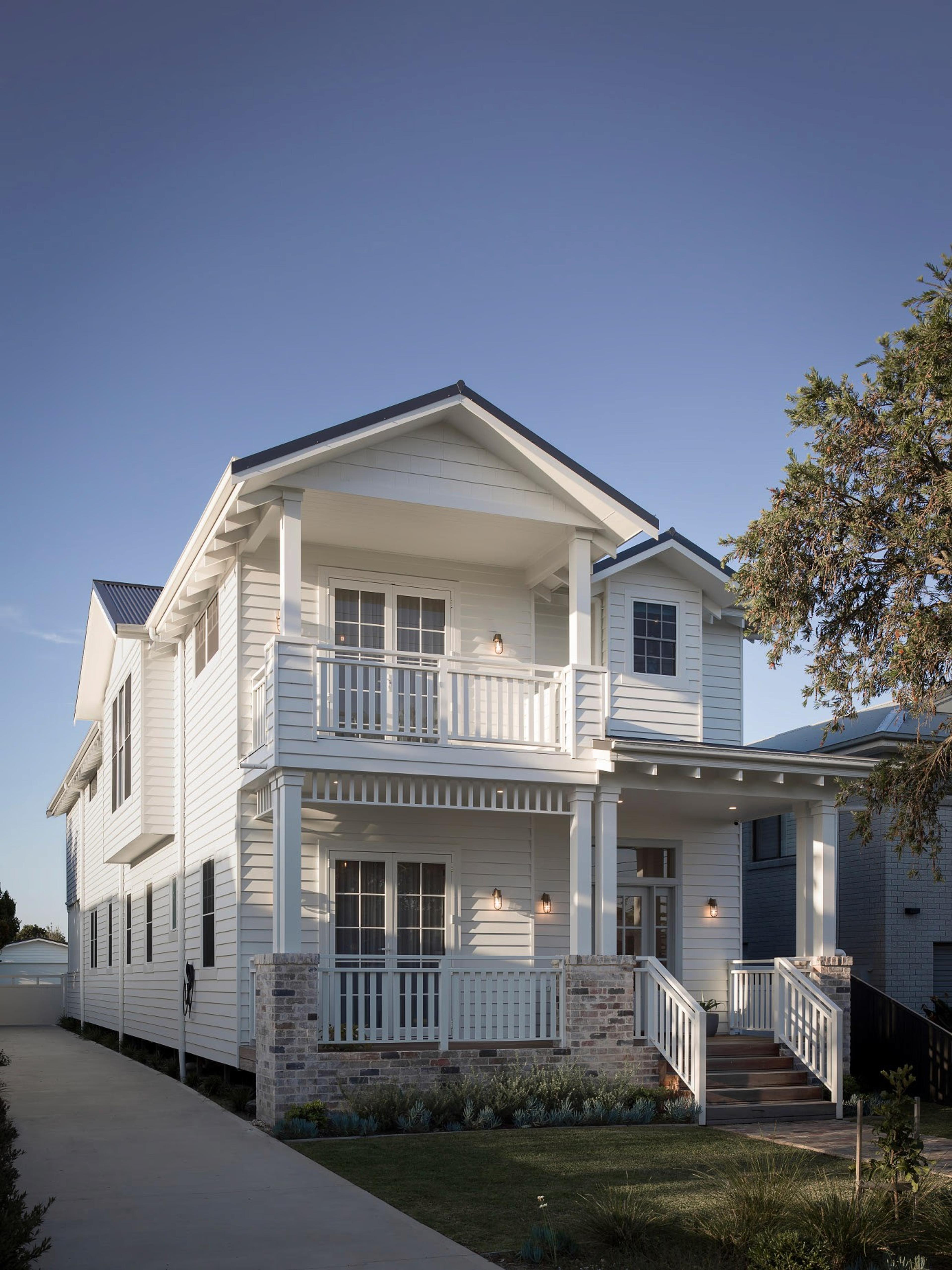 Two storey white weatherboard home front facade at dusk