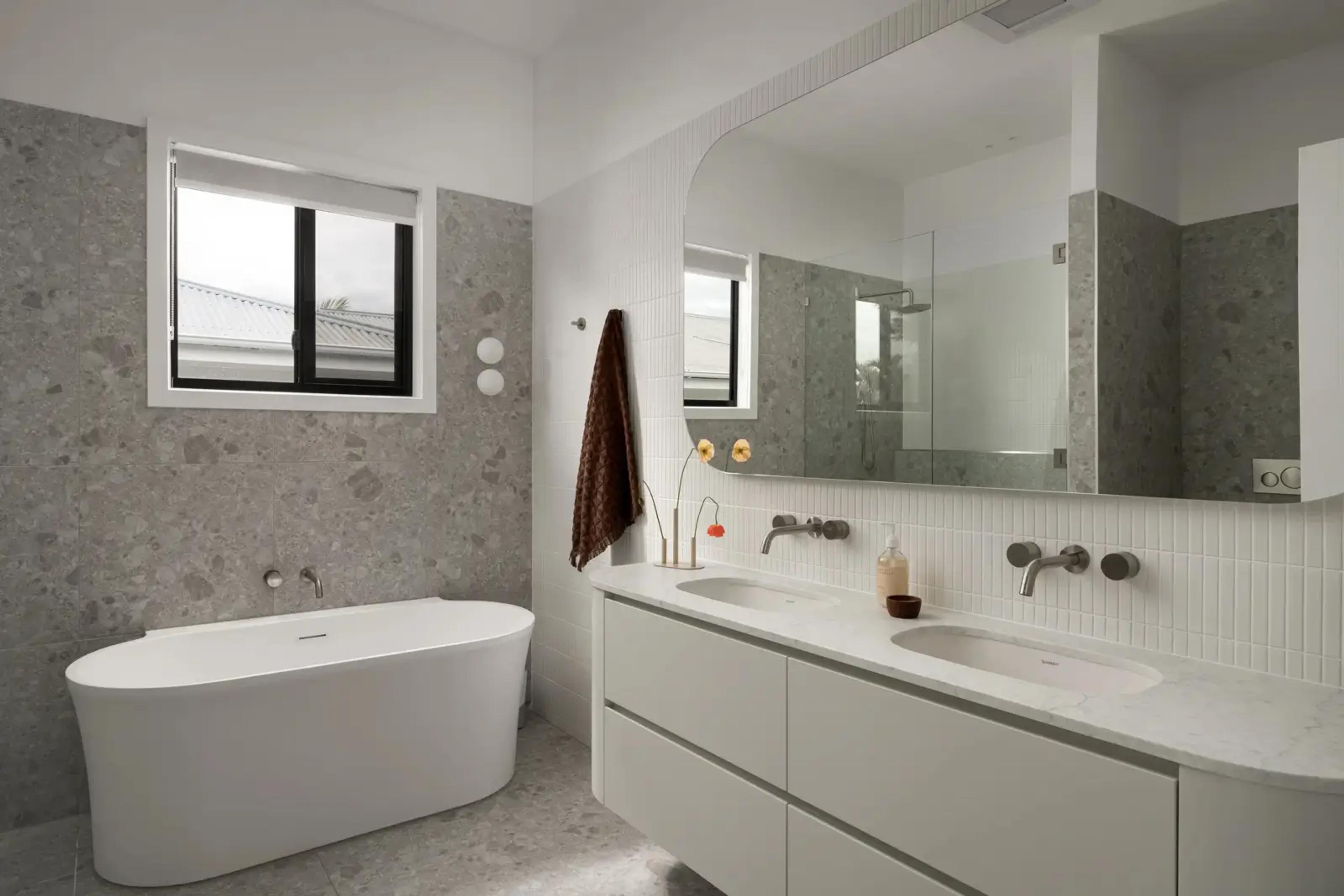 Bathroom with freestanding tub, stone tiling and double vanity