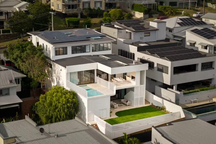 Aerial view of Prelude, a custom home by Invilla Architecture stepping down a sloping block in Bulimba with a pool terrace above the garden.