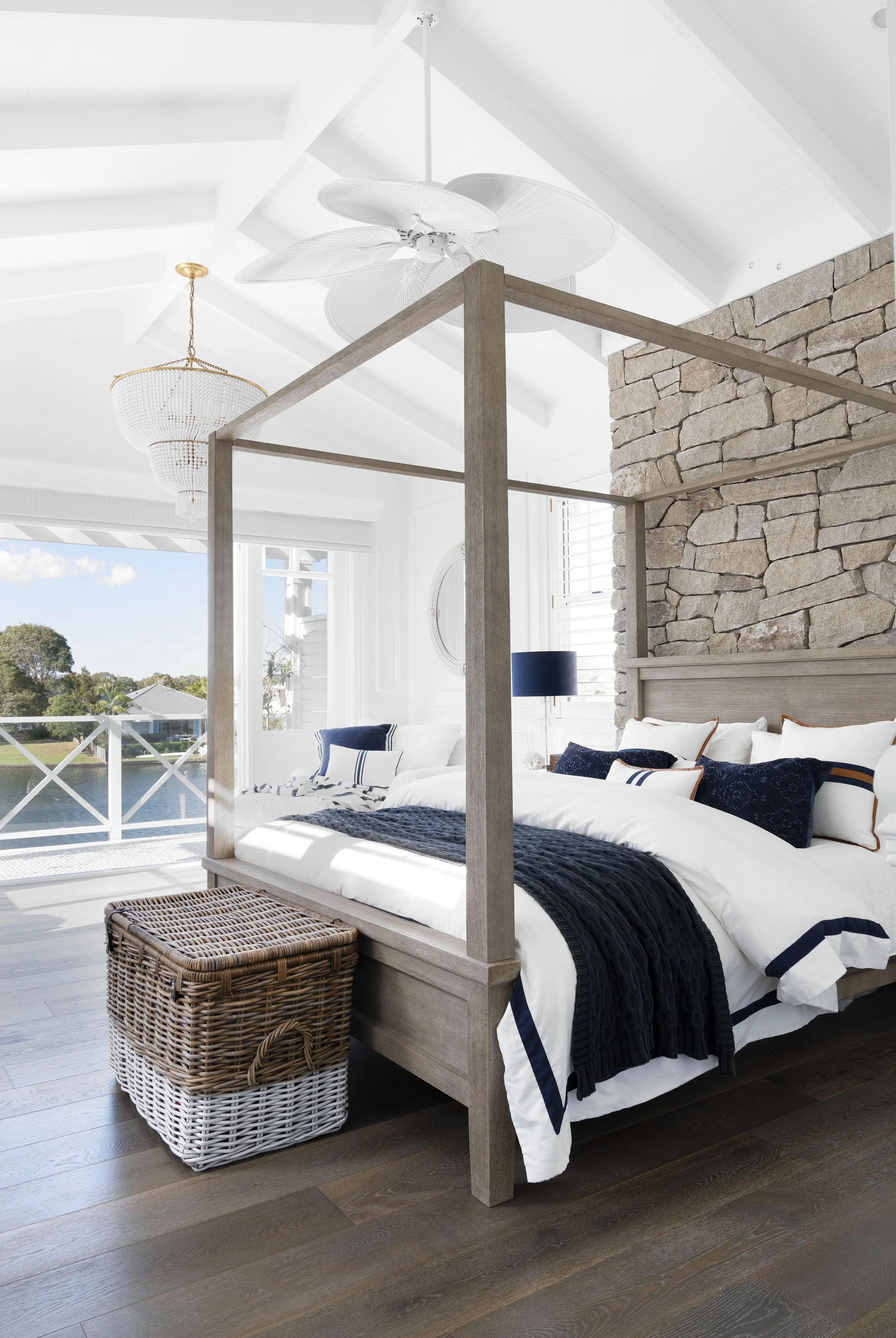 Main bedroom with timber four poster bed and stone feature wall