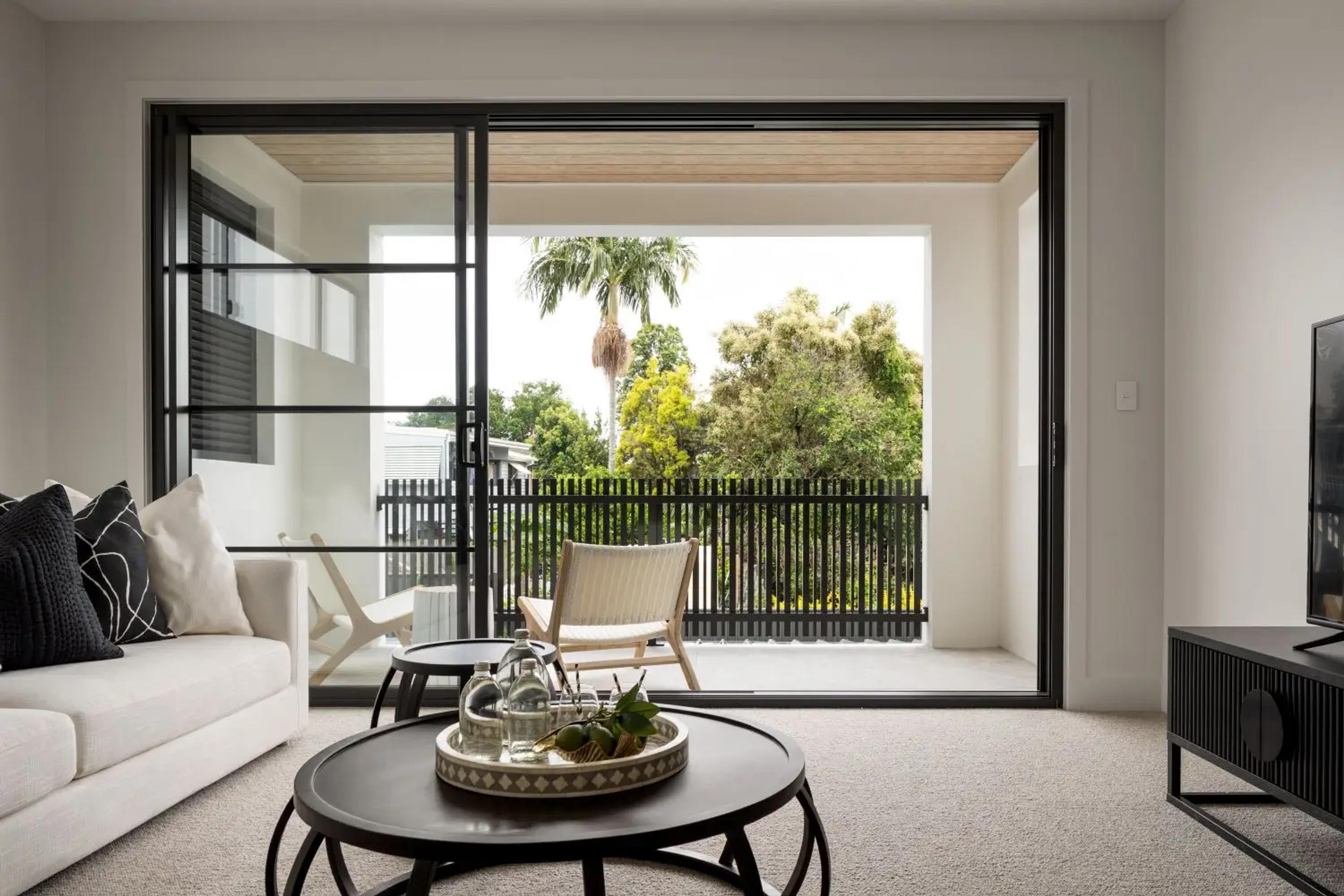 Sitting room opening to balcony with treetop outlook