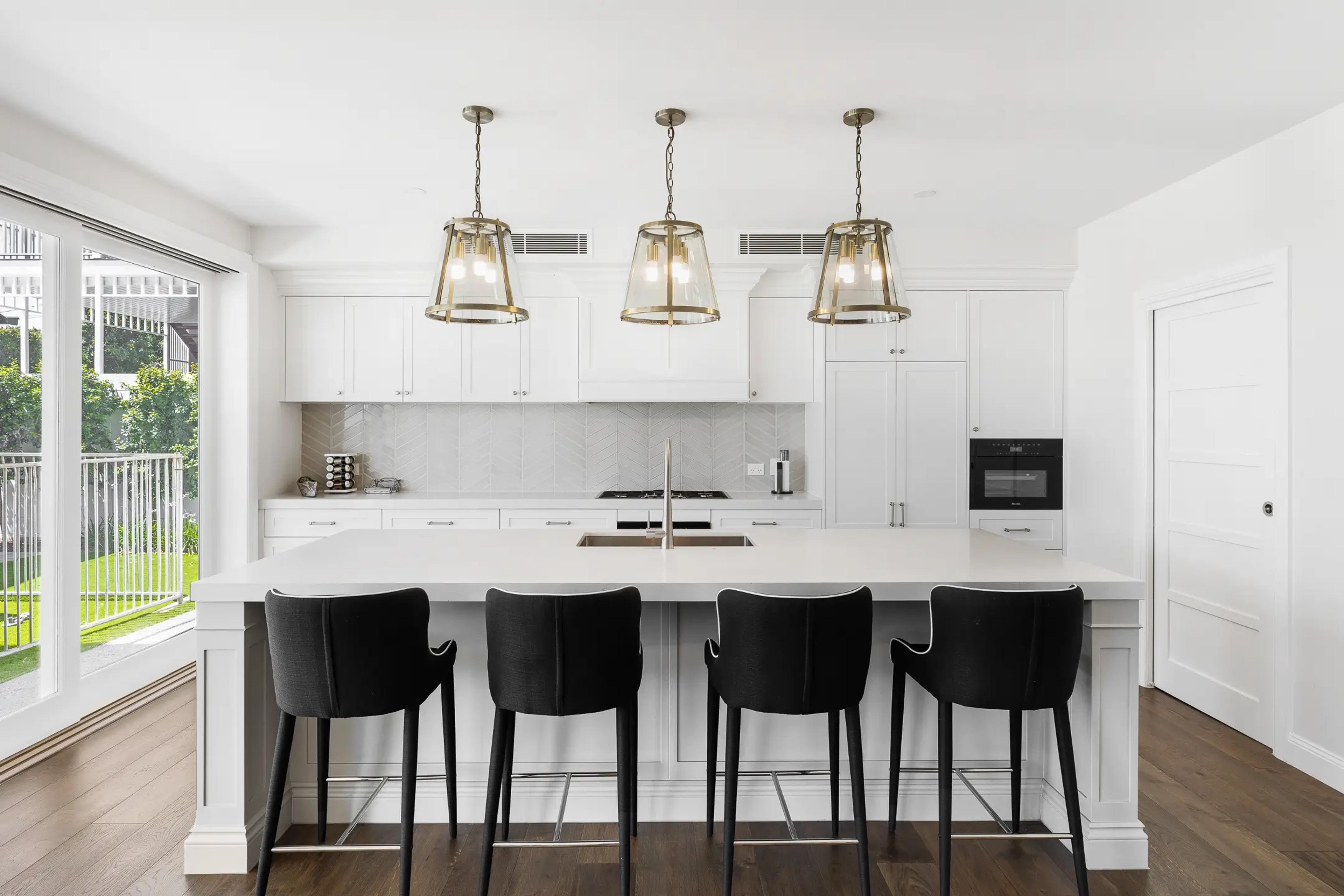 White kitchen with island bench and pendant lighting