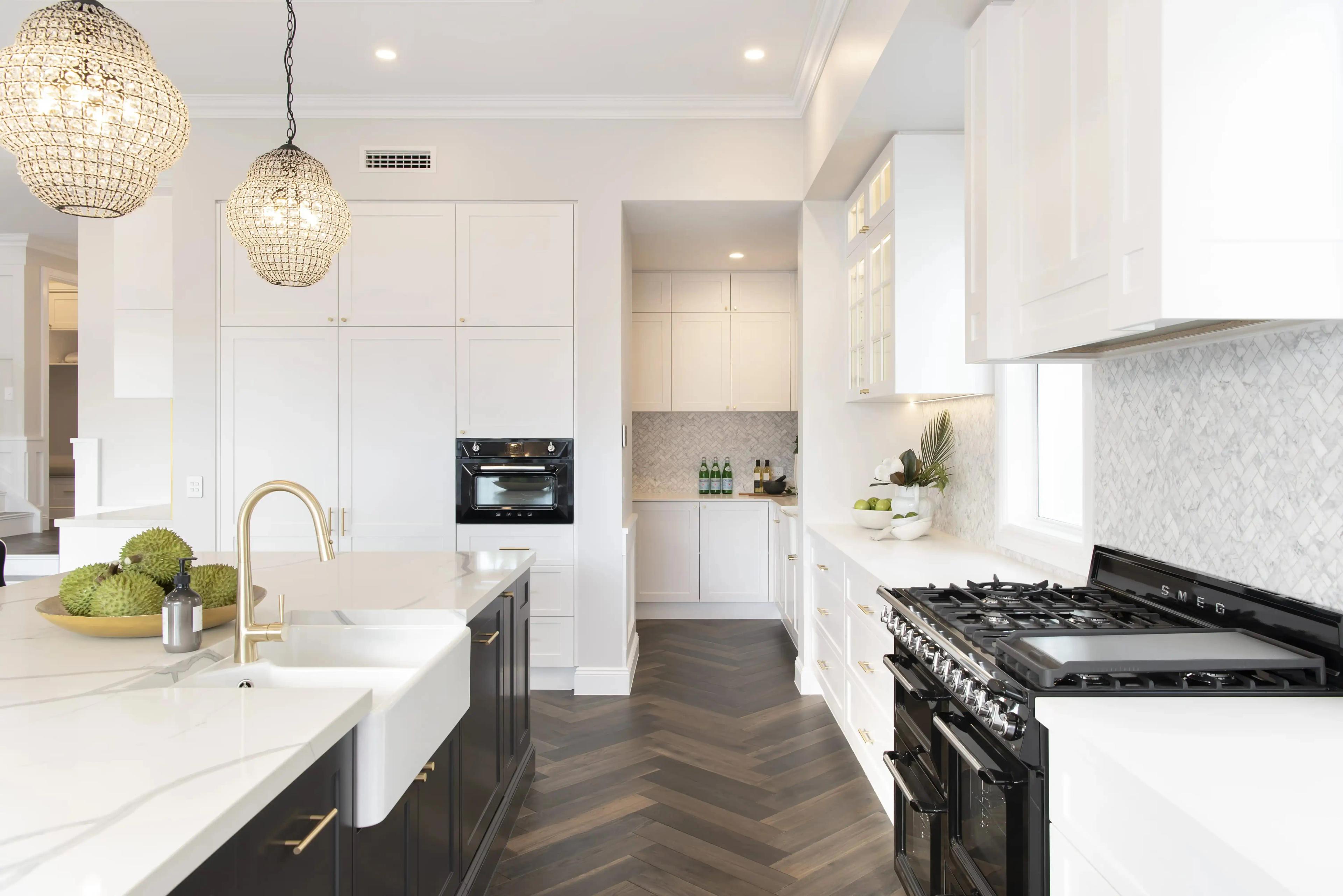 Kitchen featuring key elements in Australian Hamptons style shaker cabinetry, stone benchtops, a statement island and gold tapware