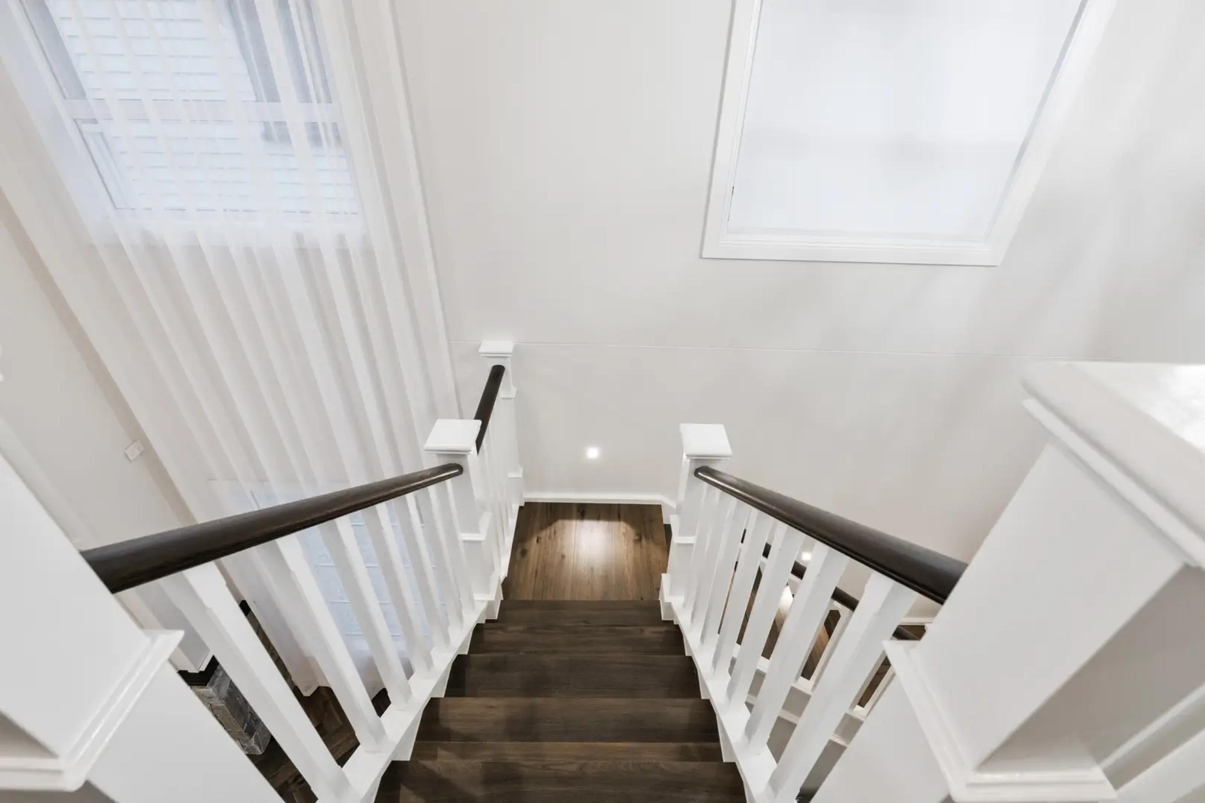 Timber staircase viewed from above with white balustrade