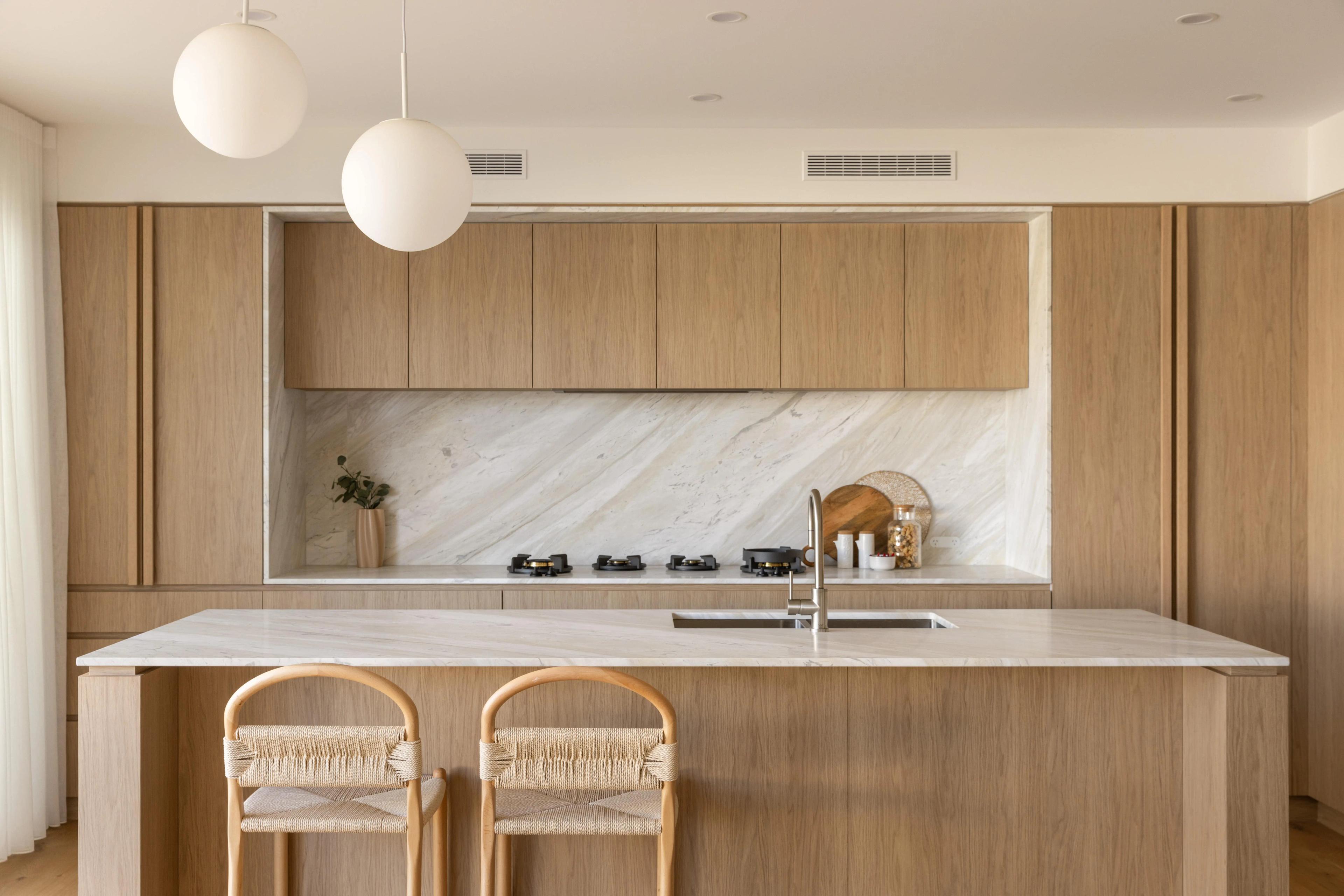 Timber kitchen with marble island bench and pendant lights
