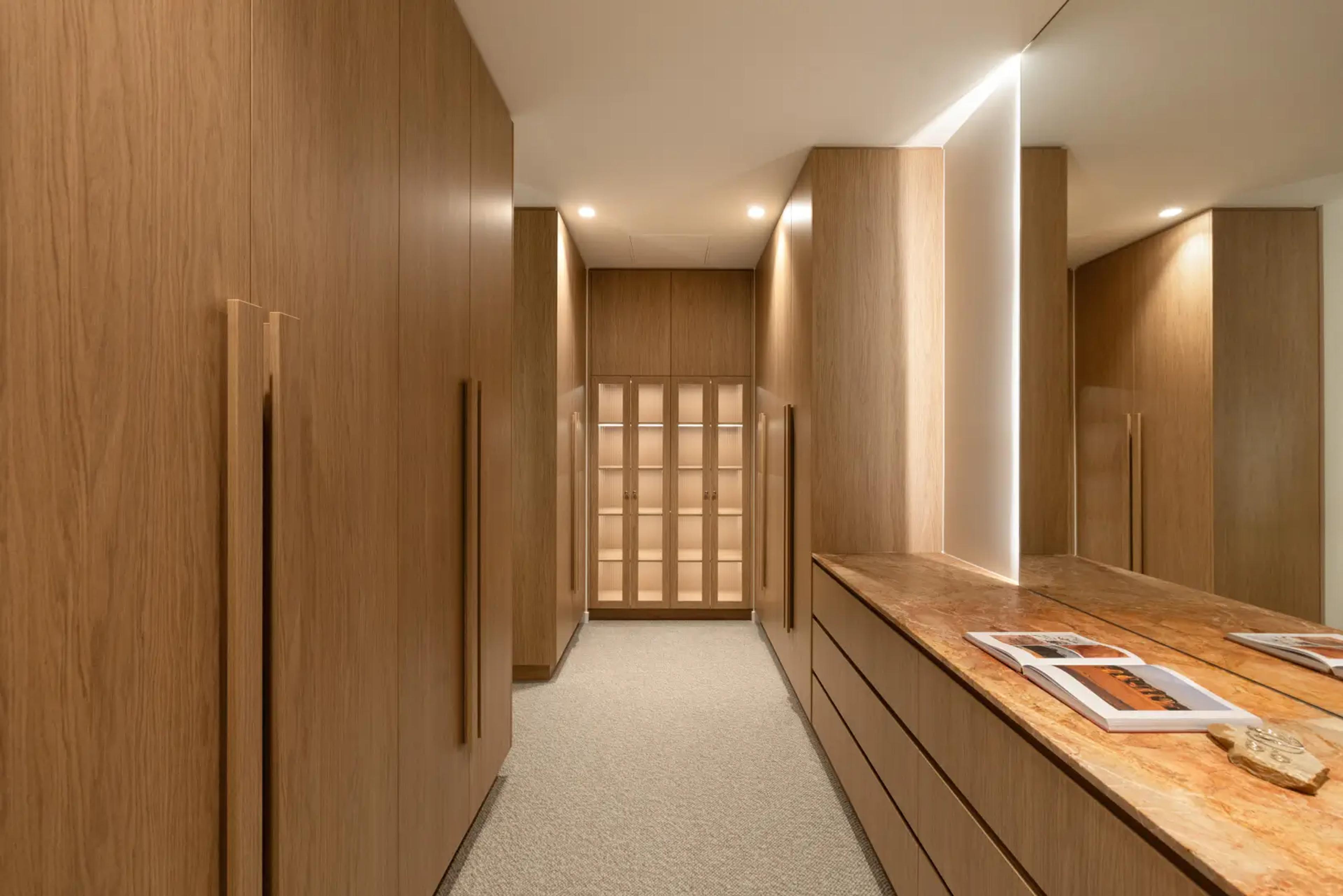 Walk-in wardrobe with timber joinery and stone bench