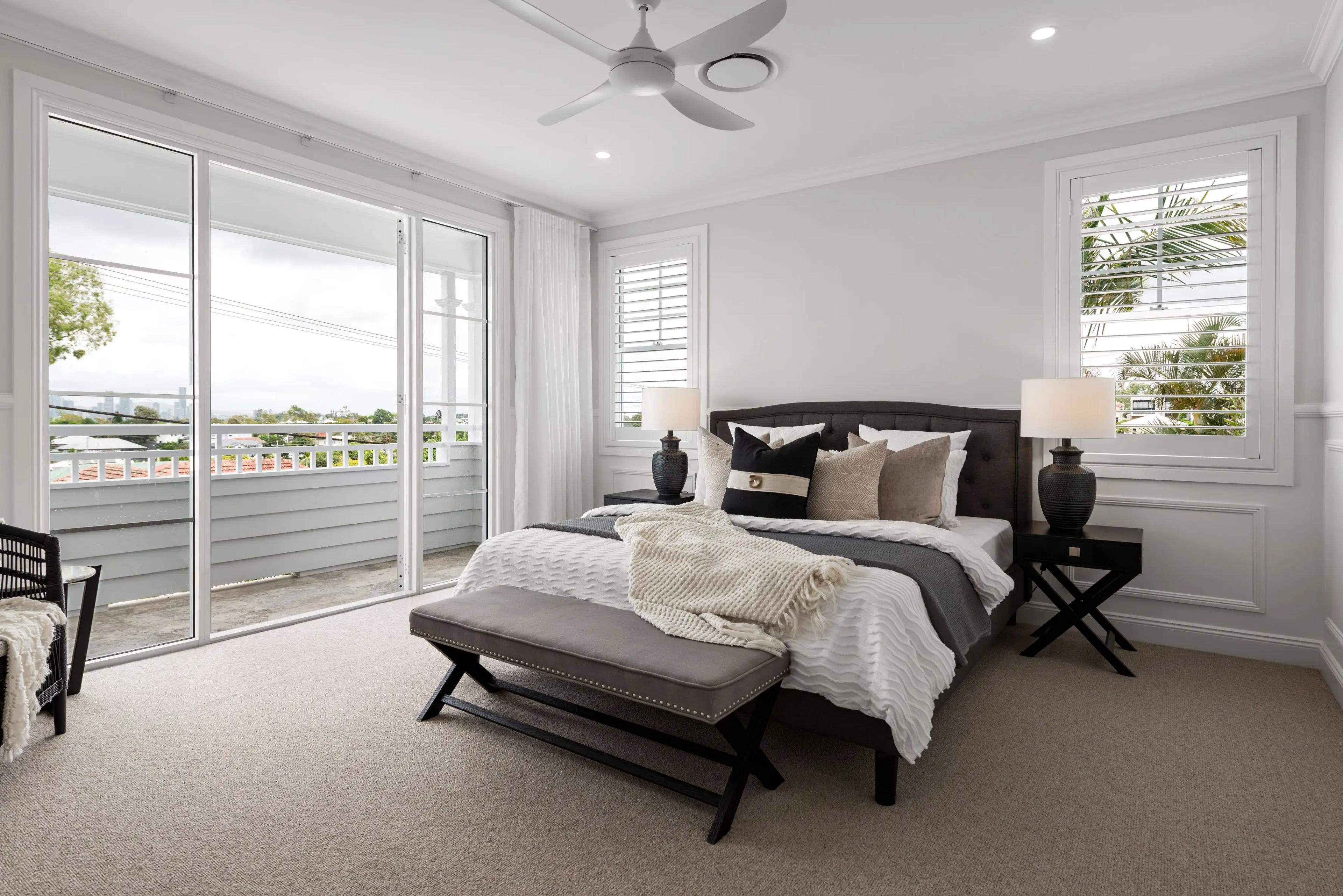 Main bedroom with dark bedhead and doors to balcony