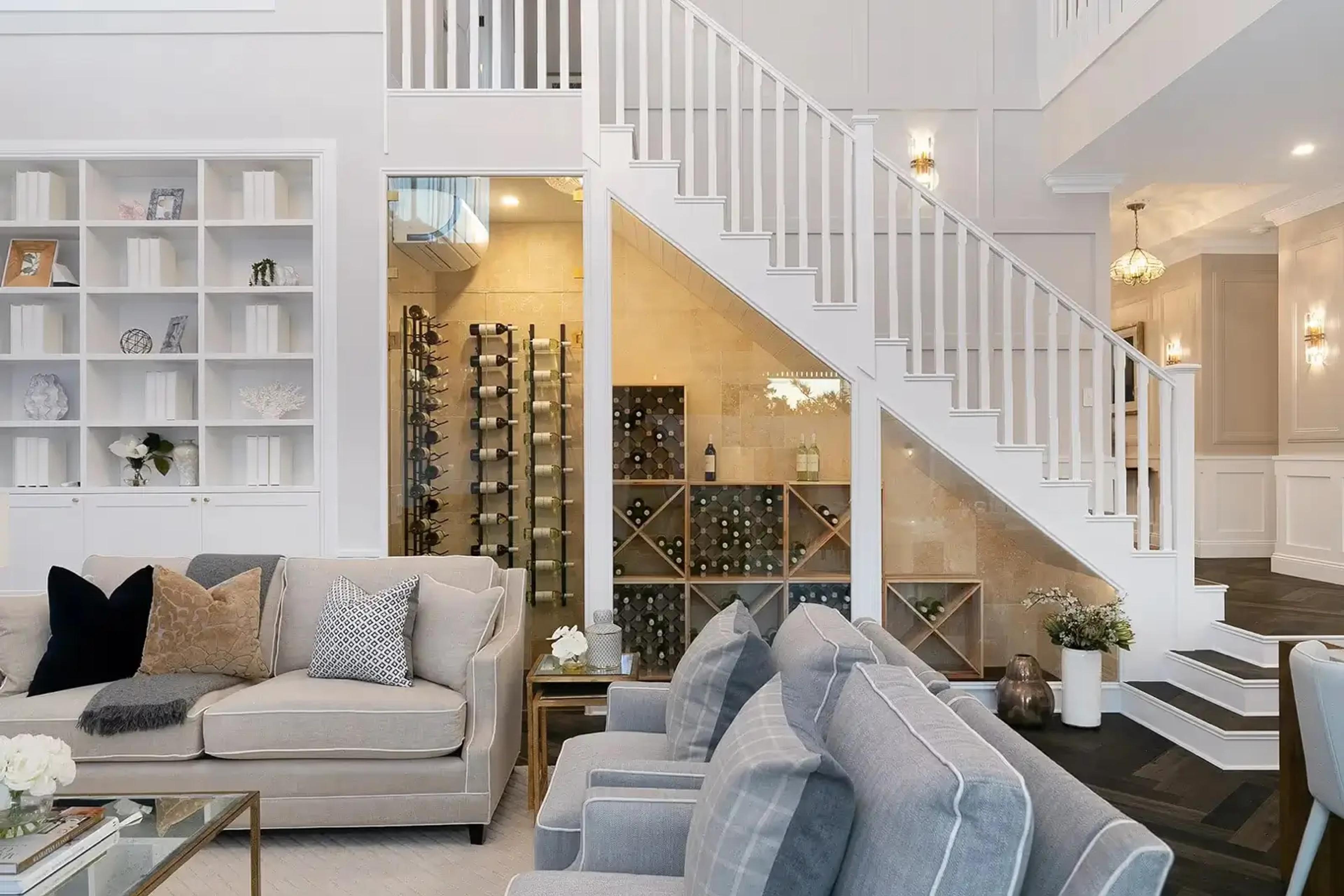 Living room with staircase, glass wine cellar and built in shelving