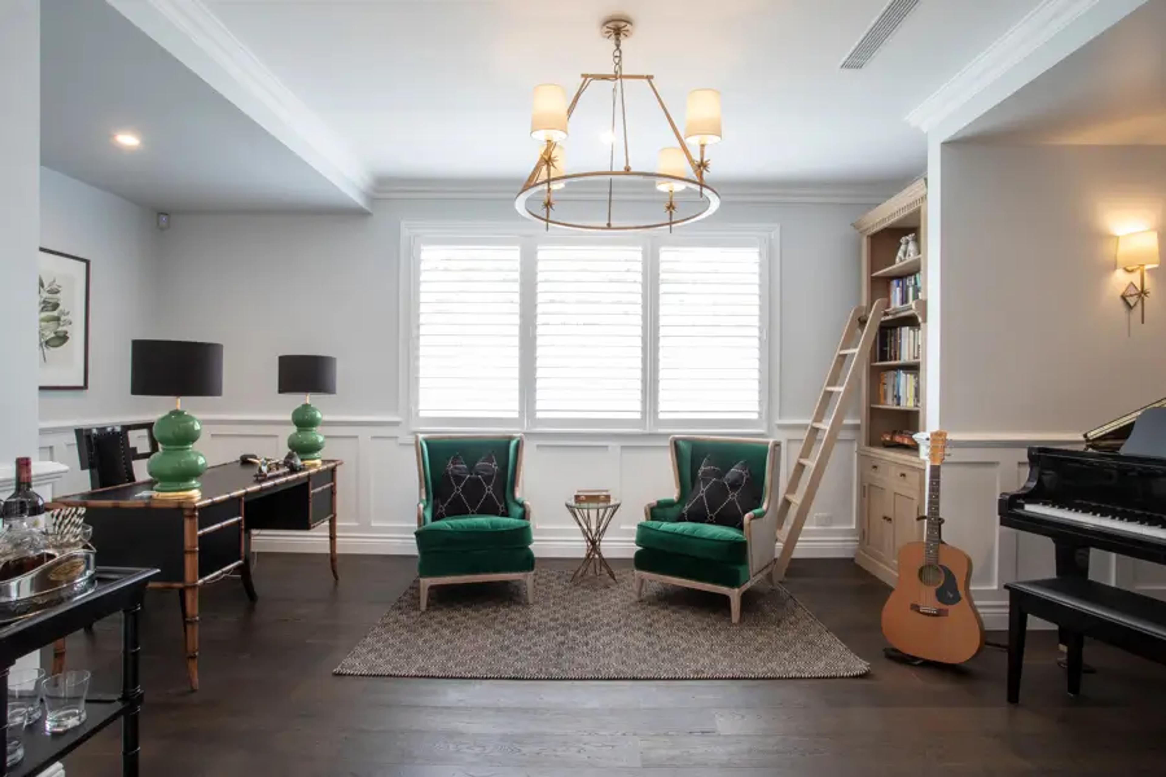 Study with desk, green armchairs and grand piano