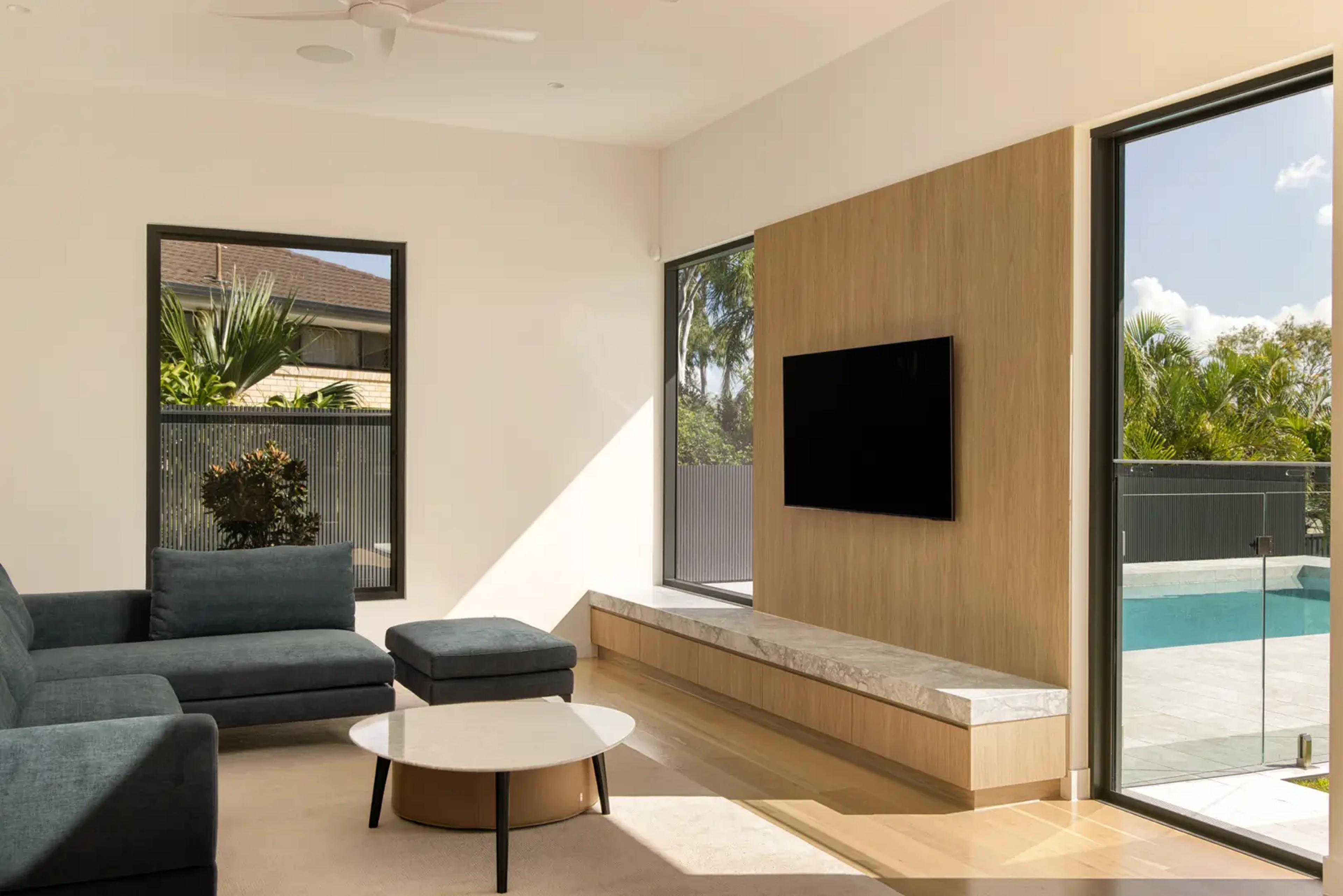 Living room with grey sofa and view to pool