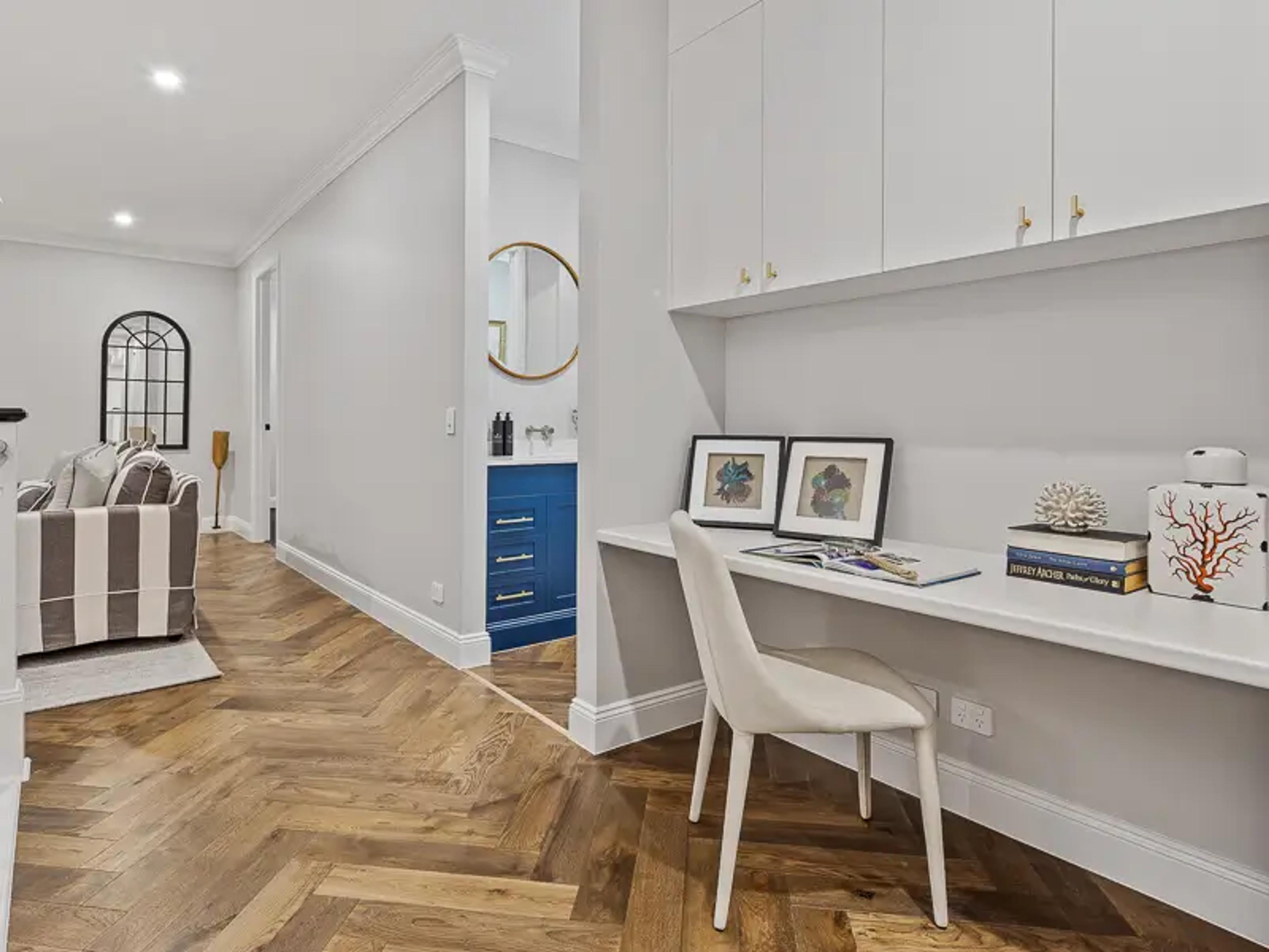 Built in study nook with desk beside hallway and powder room