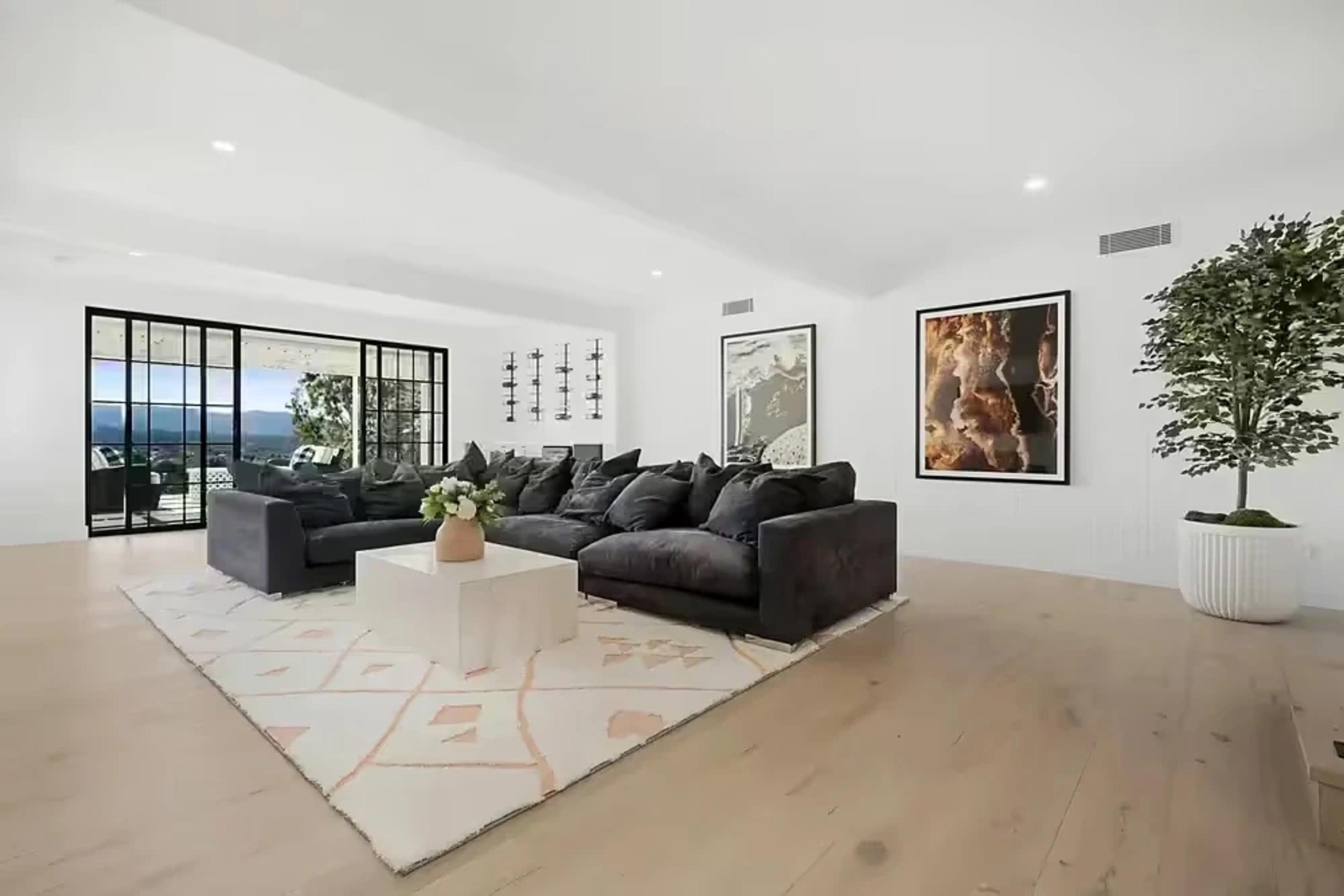 Living room with charcoal sectional sofa and framed artwork.